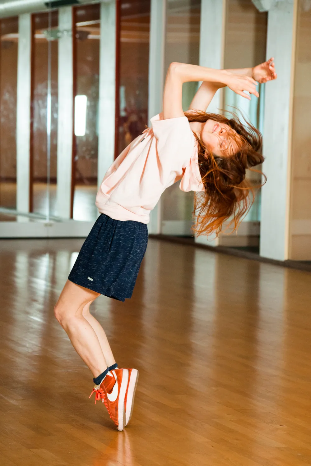Kassandra Wedel, deaf professional dancer and choreographer, arching backwards in a dance studio — commercial campaign photography by Janina Laszlo for AOK