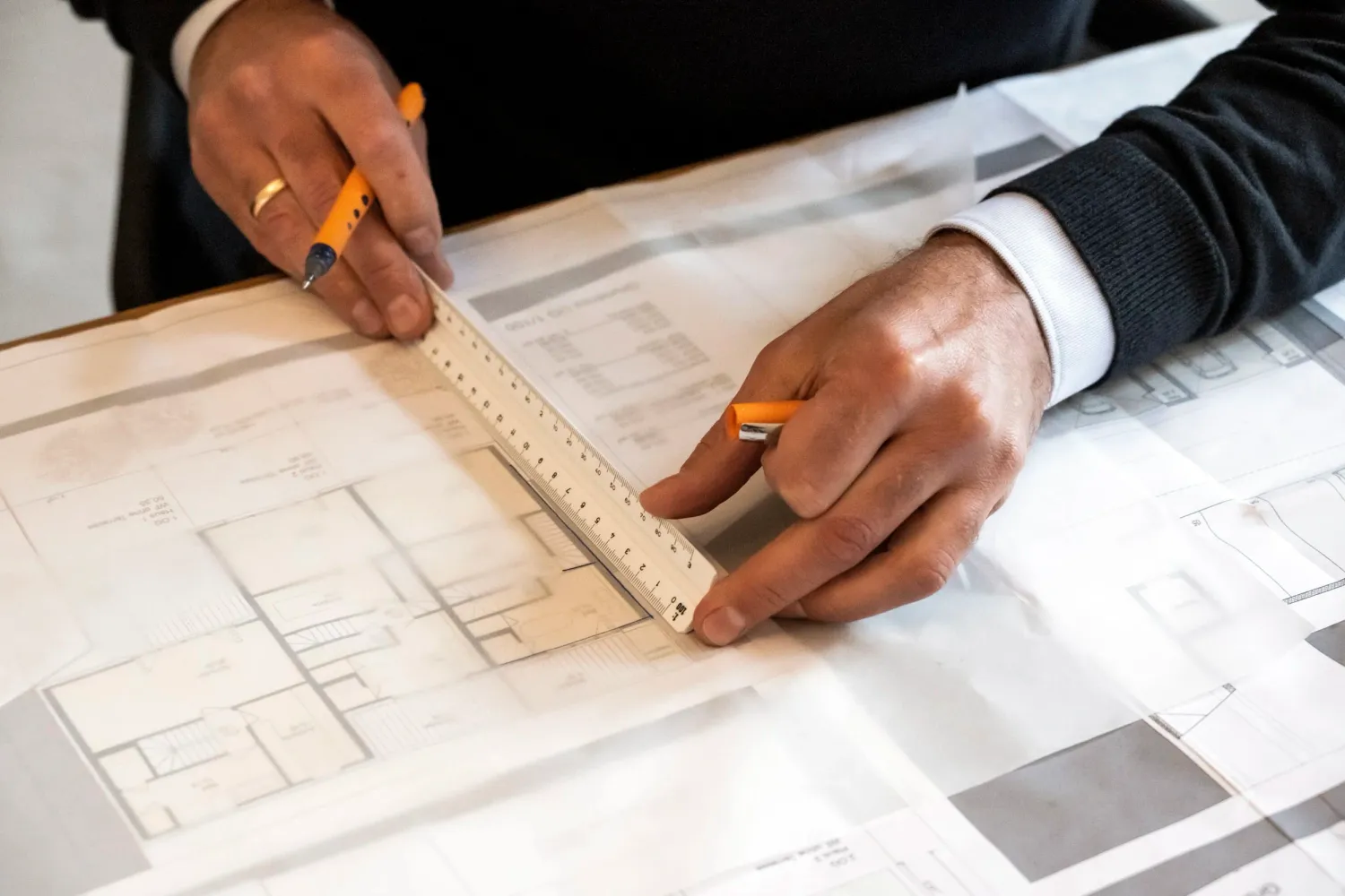 Architect's hands drawing with a set square on a floor plan — architectural office Helmling — portrait by Janina Laszlo, portrait photographer in Munich
