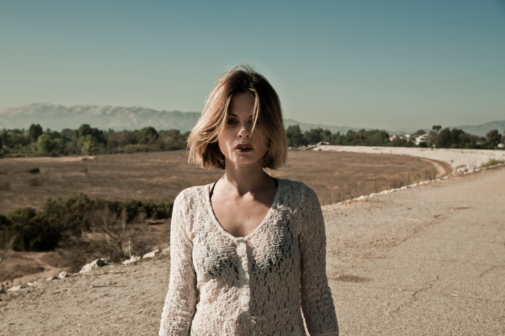 Augie Duke in a cream knit sweater on a dirt road in warm evening light — Augie Duke, actor portrait photography by Janina Laszlo