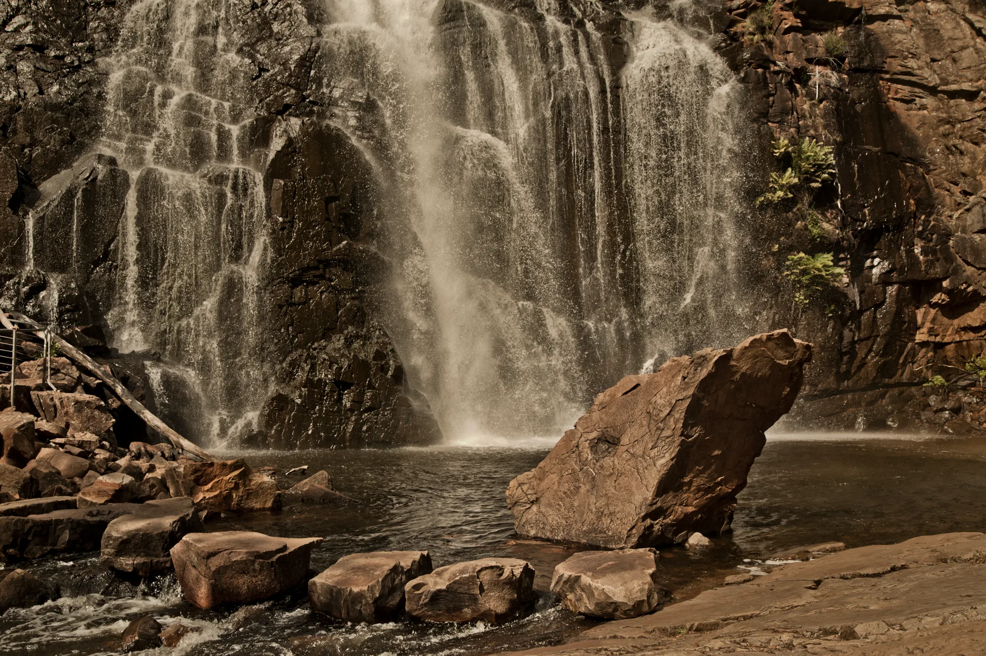 MacKenzie Falls cascading over dark rock into a pool with stepping stones, Grampians National Park, Victoria — Australia, travel and fine art photography by Janina Laszlo