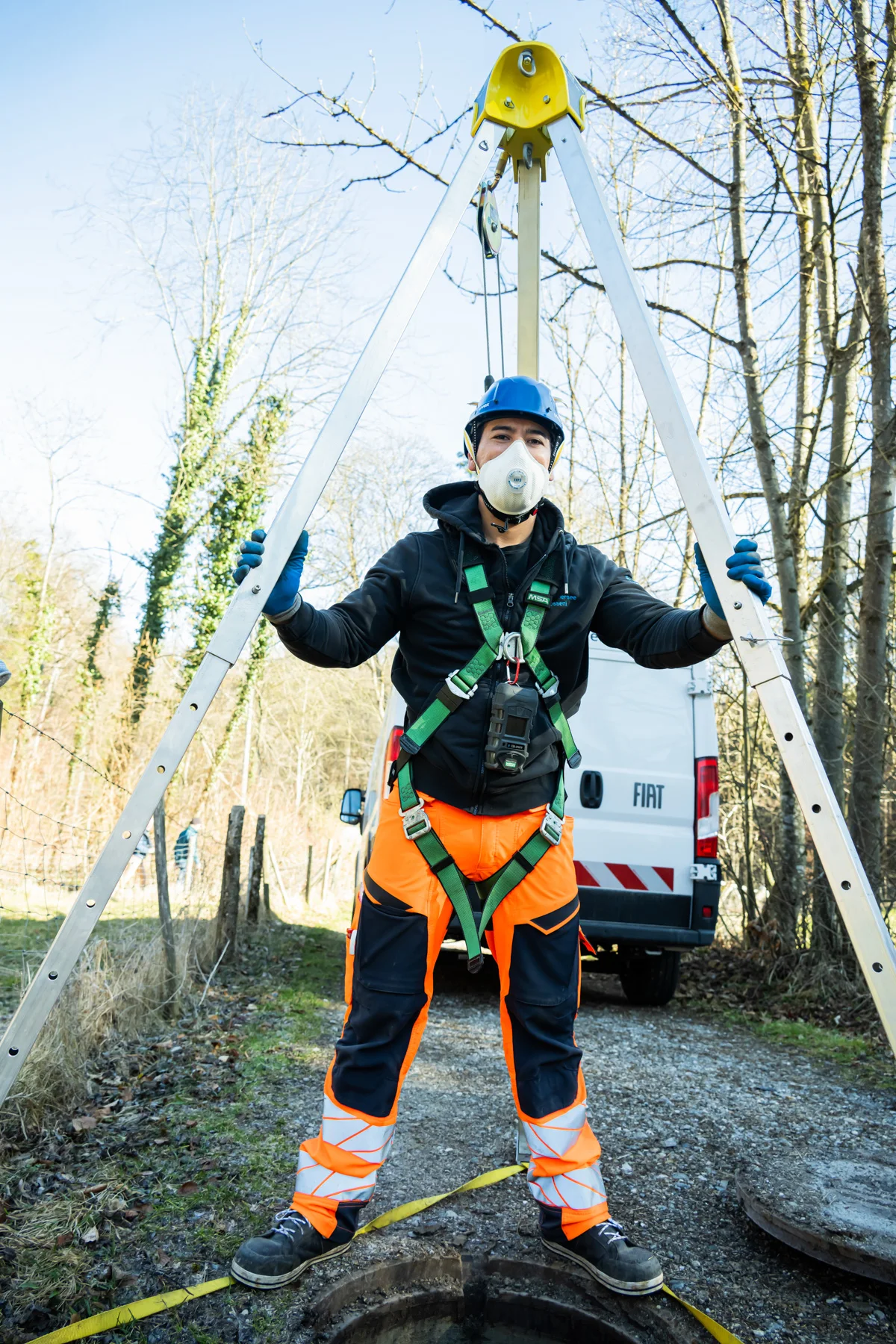Sewer worker in harness and helmet standing under a rescue tripod — AWA Ammersee, industrial, corporate and portrait photography by Janina Laszlo