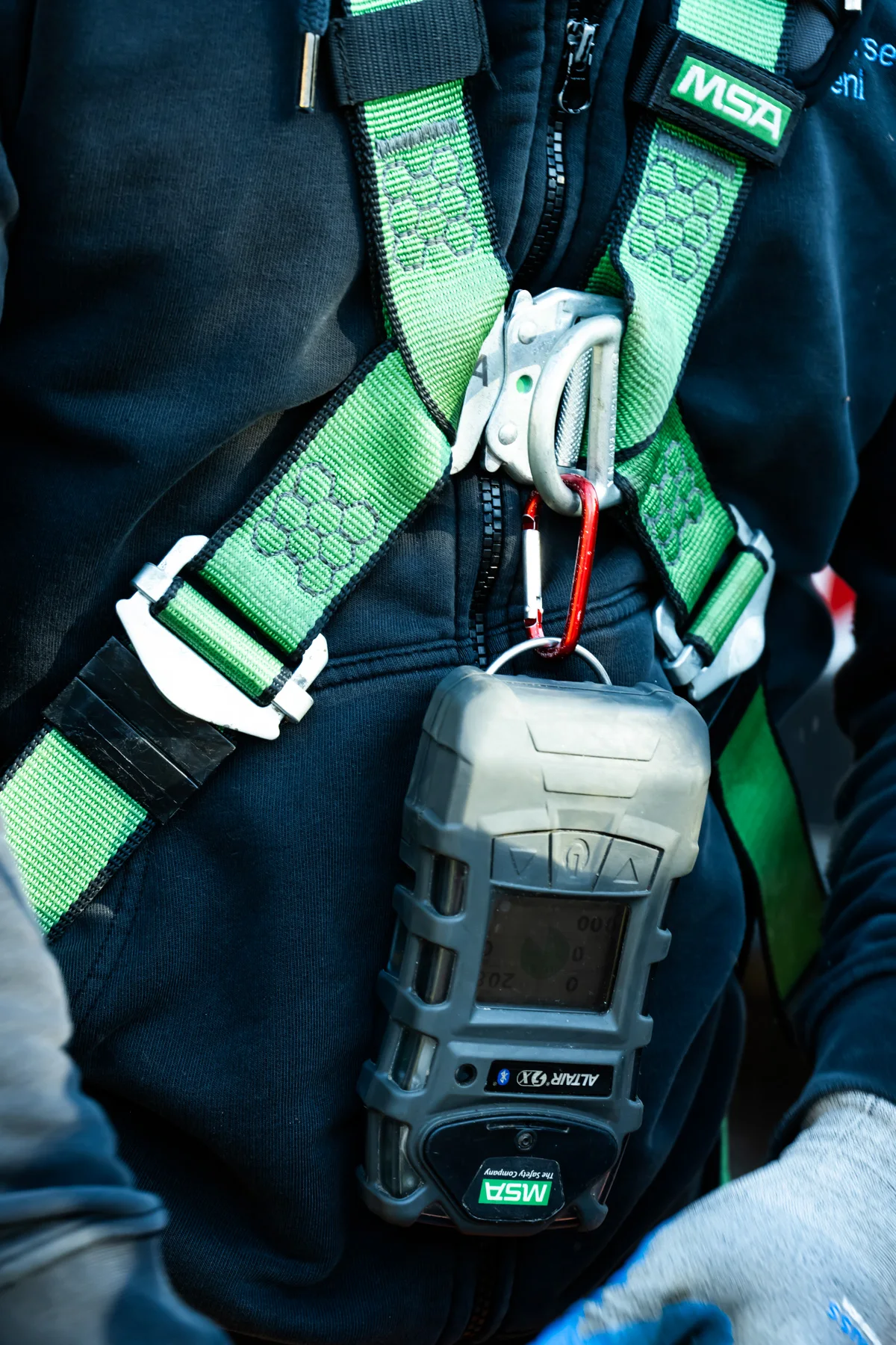 Gas detector clipped to a green safety harness, close-up — AWA Ammersee, industrial, corporate and portrait photography by Janina Laszlo