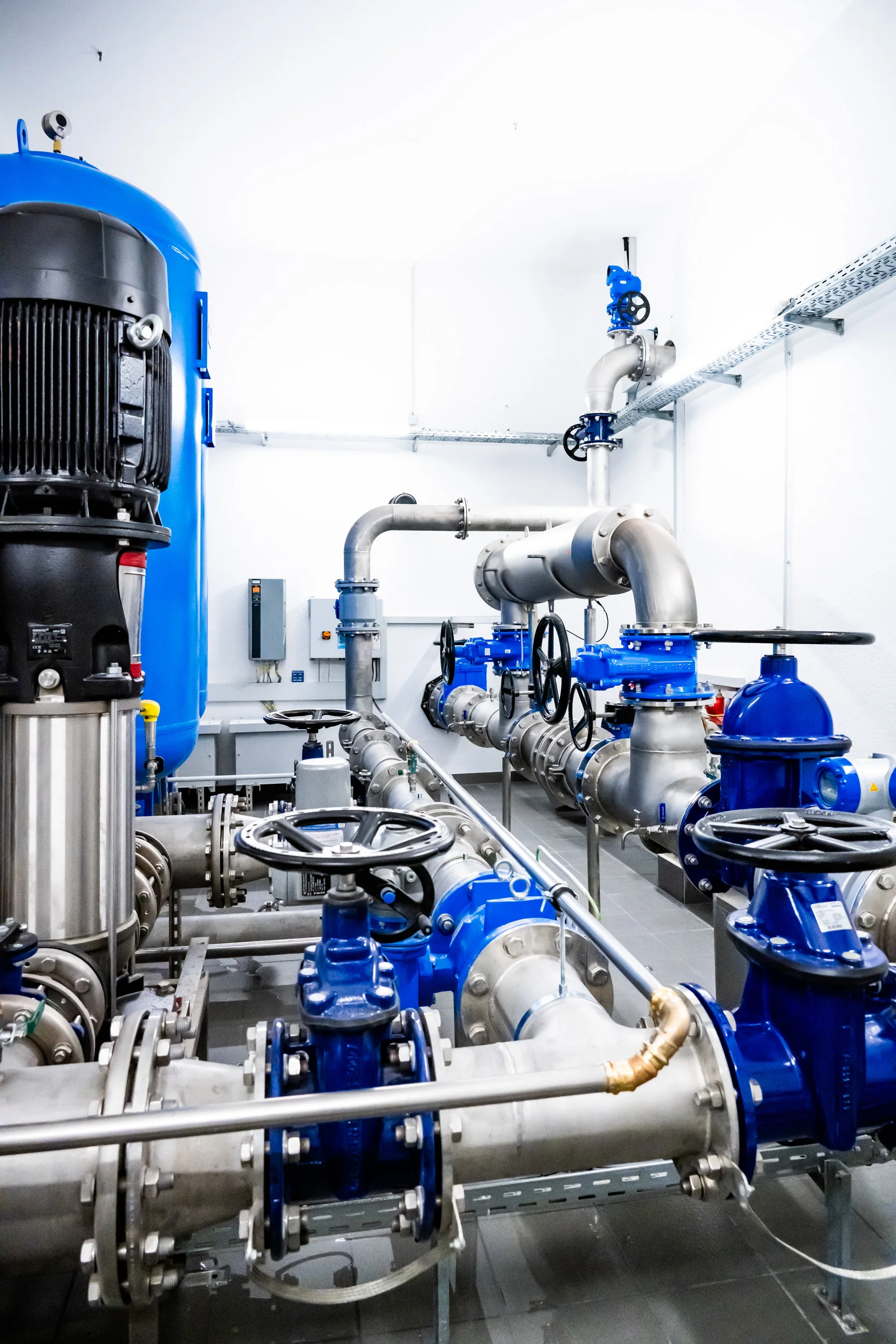 Blue pumps and gate valves on stainless steel pipework, waterworks — AWA Ammersee, industrial, corporate and portrait photography by Janina Laszlo