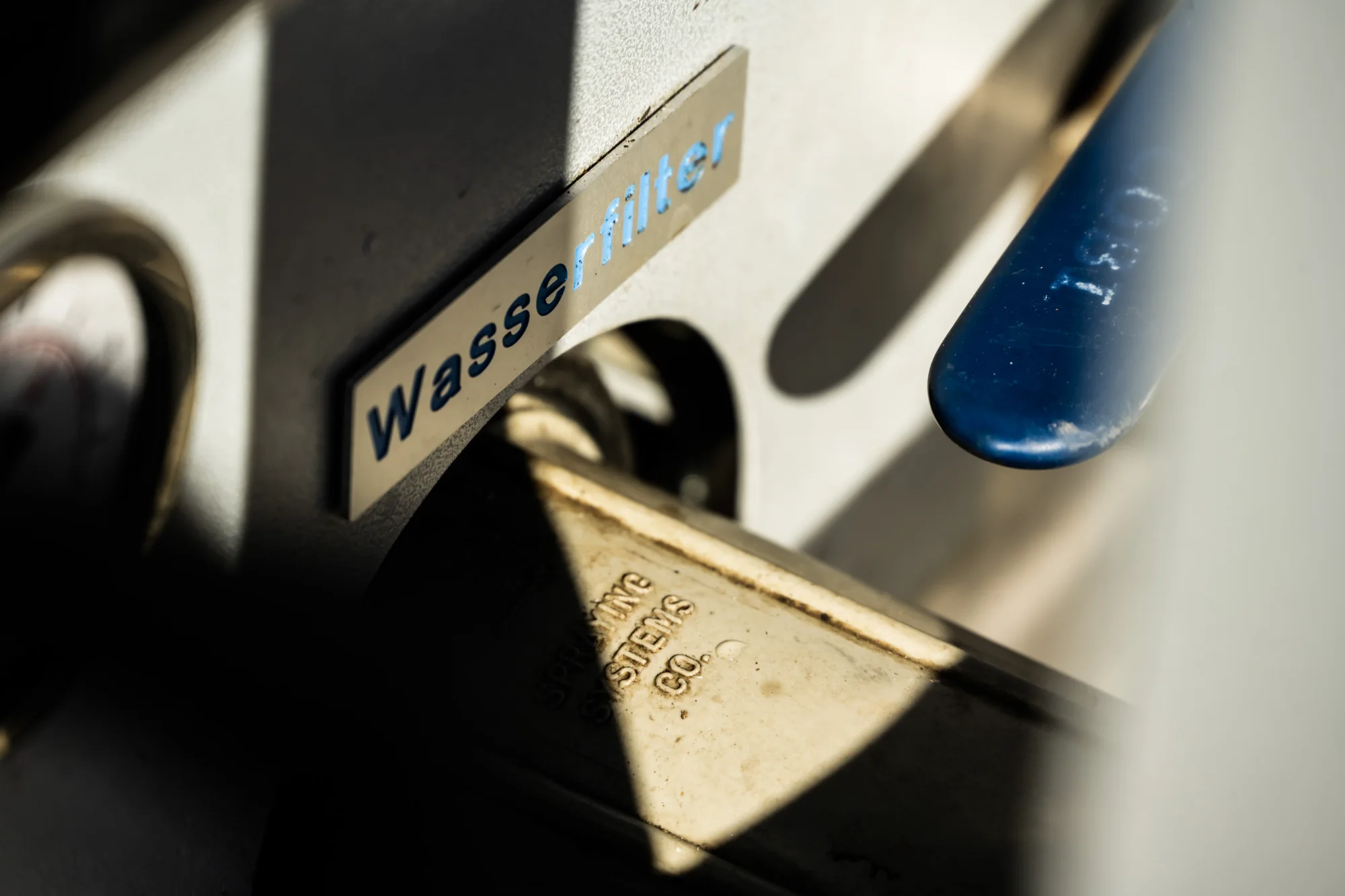 Stainless steel plate labelled Wasser on a machine housing, close-up — AWA Ammersee, industrial, corporate and portrait photography by Janina Laszlo