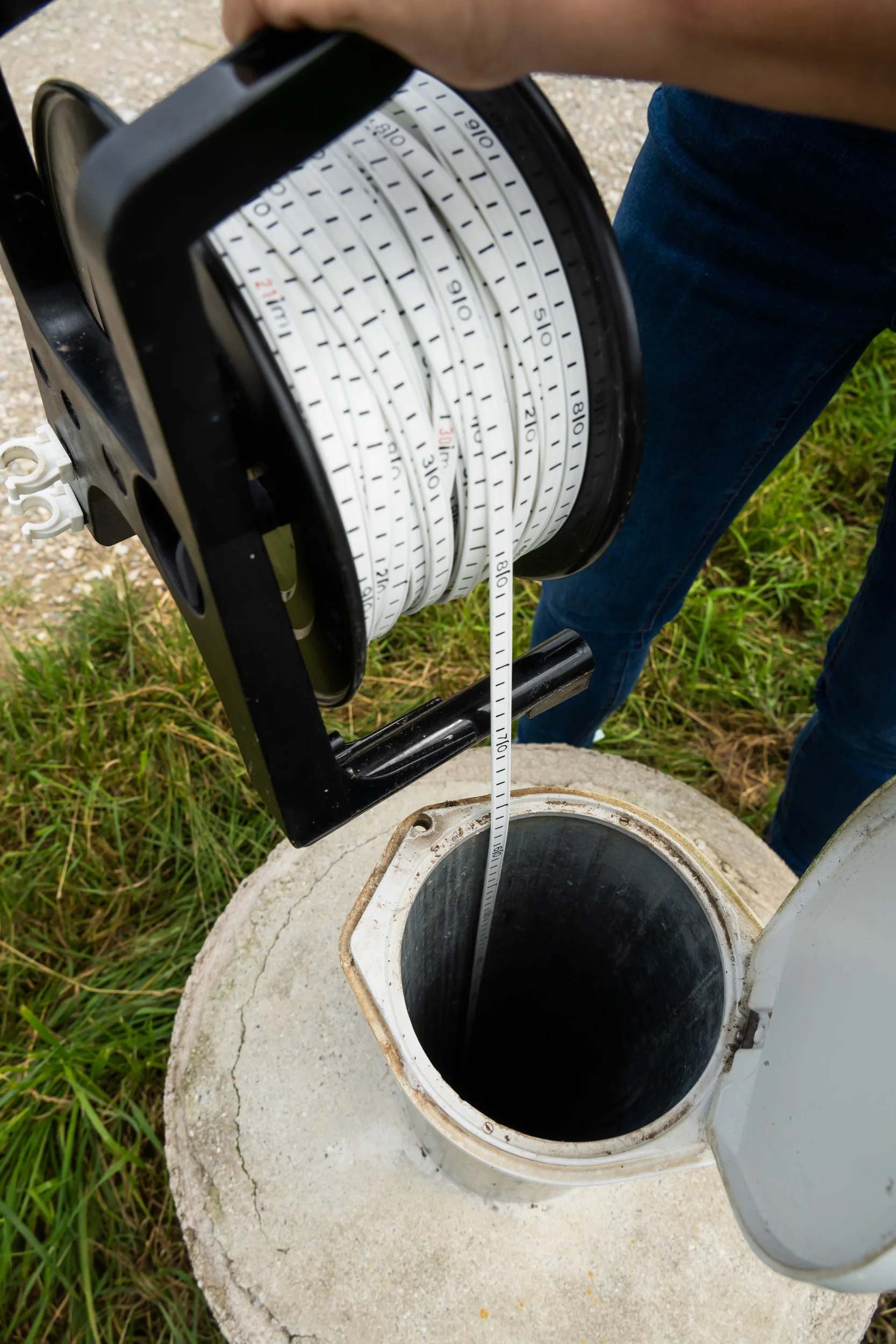 Groundwater level meter tape lowered into a monitoring well — AWA Ammersee, industrial, corporate and portrait photography by Janina Laszlo
