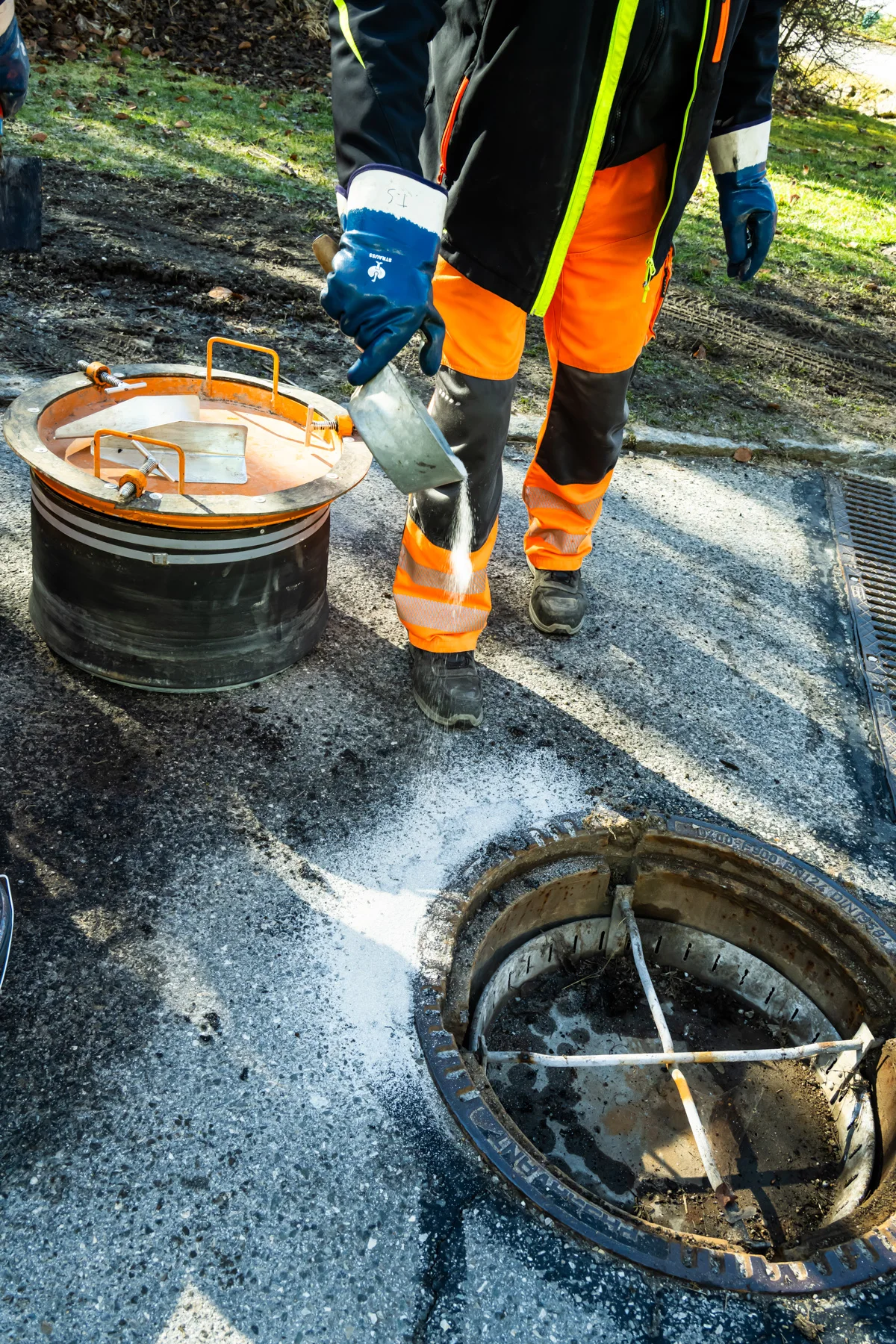 Worker lifting a manhole cover, steam rising from the shaft — AWA Ammersee, industrial, corporate and portrait photography by Janina Laszlo