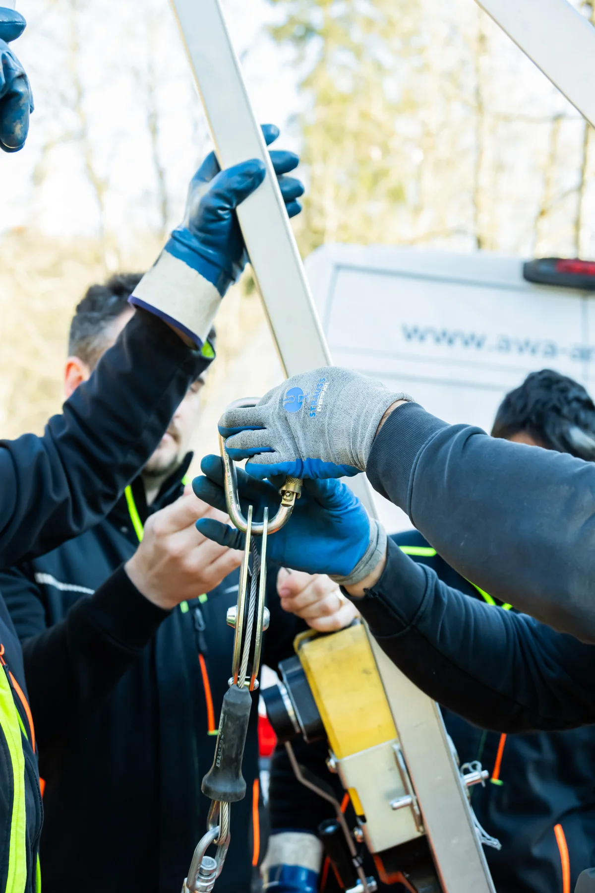 Sewer workers rigging a tripod winch with gloves before a confined-space entry — AWA Ammersee, industrial, corporate and portrait photography by Janina Laszlo