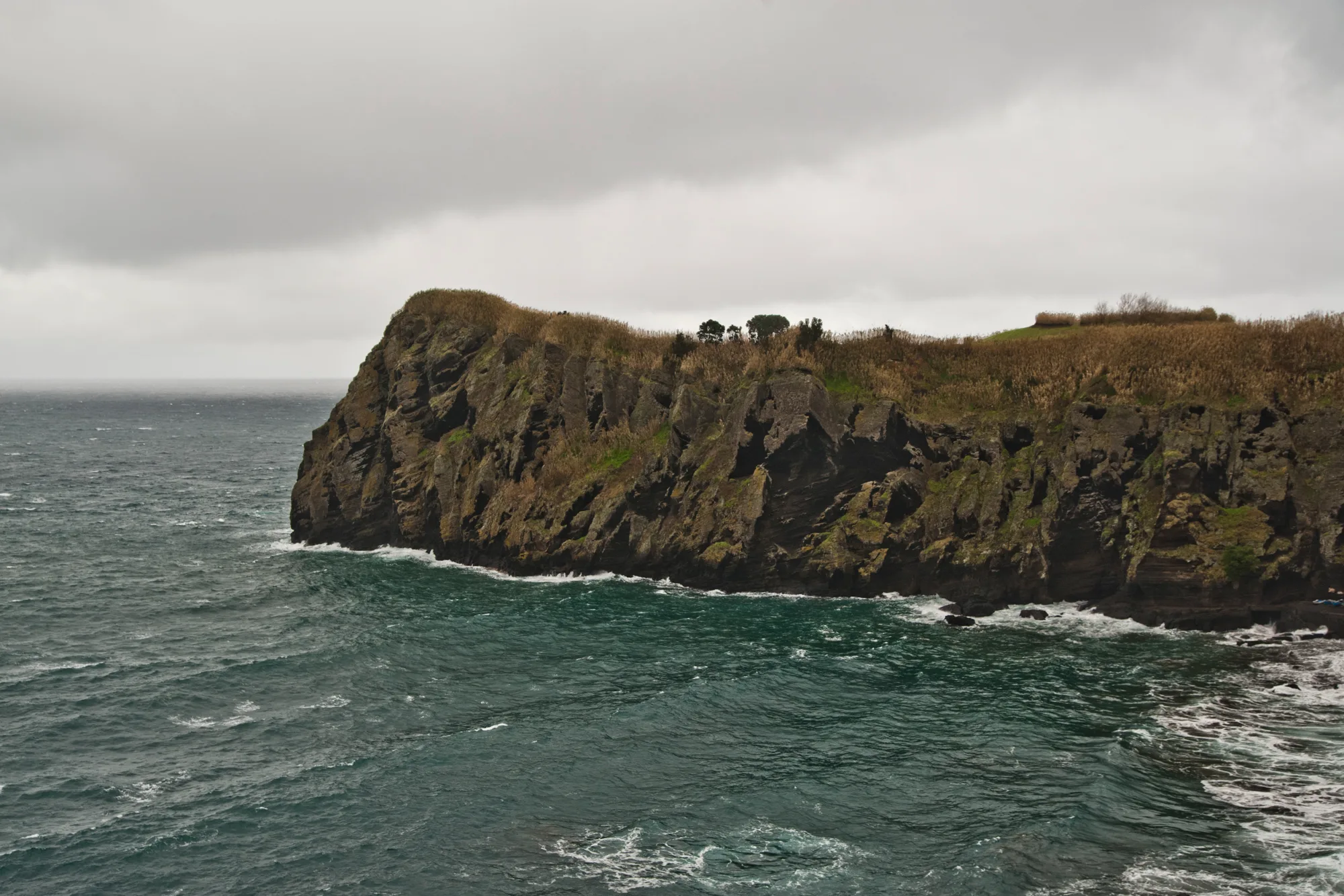 Dark volcanic cliff headland in a rough, teal Atlantic — Azores, São Miguel, travel and fine art photography by Janina Laszlo
