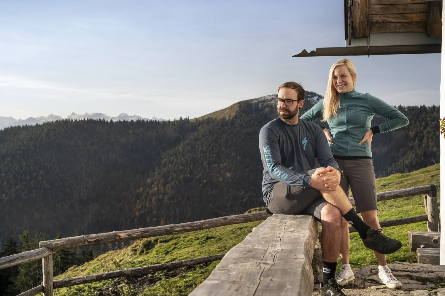 Couple taking a break on a wooden bench at a mountain hut in the Bavarian Prealps — campaign photography by Janina Laszlo, Munich