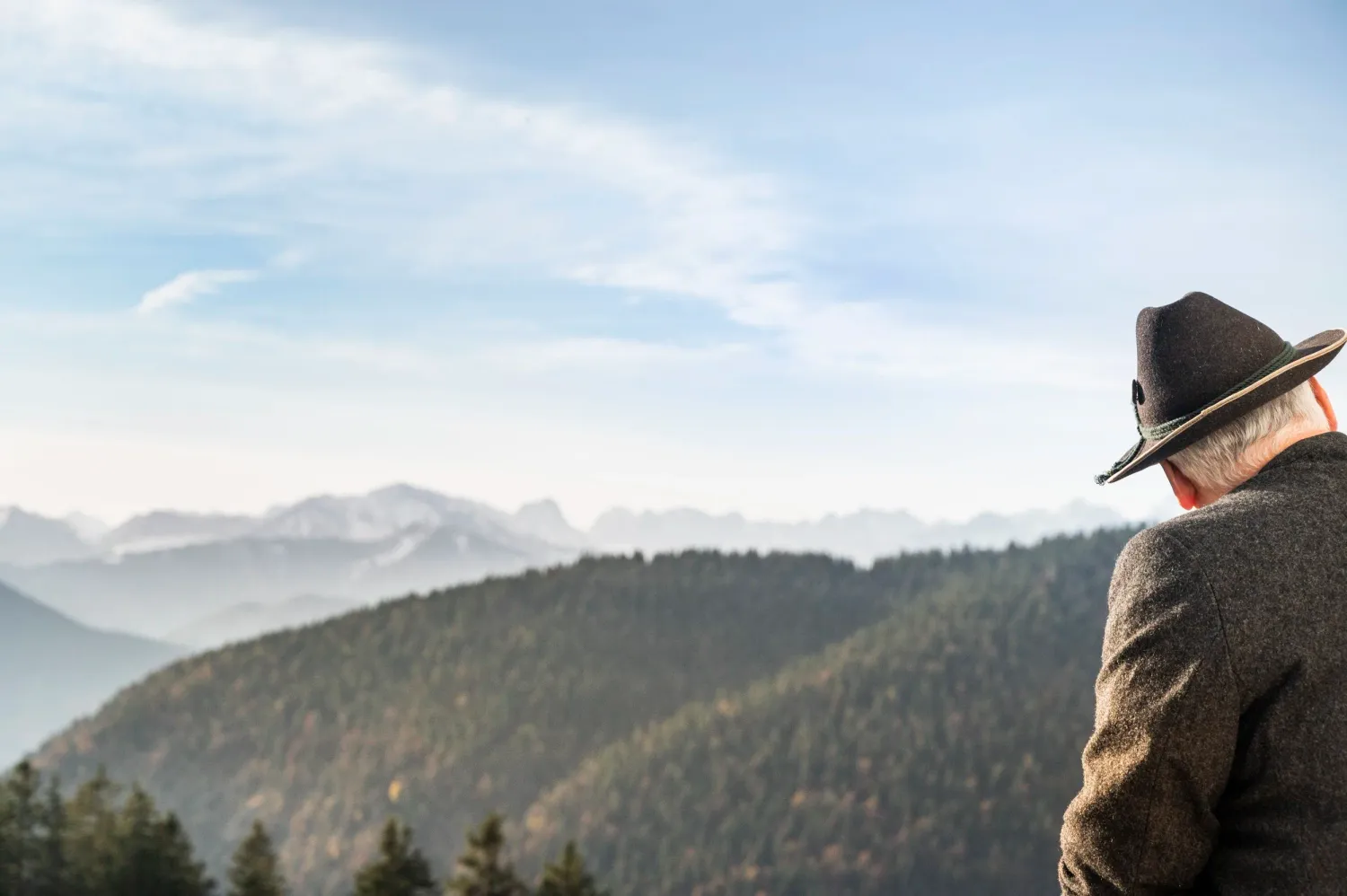 Man in a felt hat looking out over the Alpine foothills, Blaues Land, Bayerischer Tourismusverband — campaign photography by Janina Laszlo, Munich