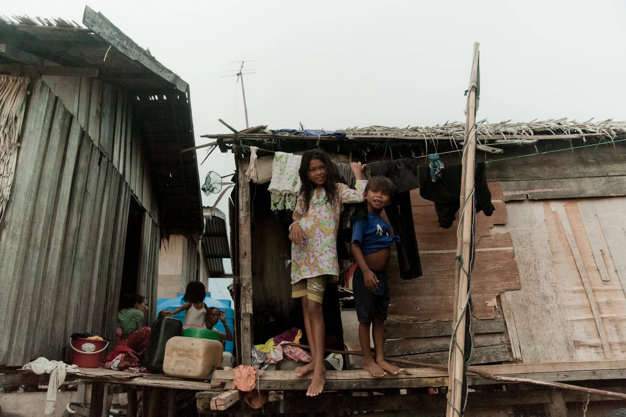 Girl and boy standing on the platform of a stilt house — Borneo & Pulau Mabul, documentary and travel photography by Janina Laszlo