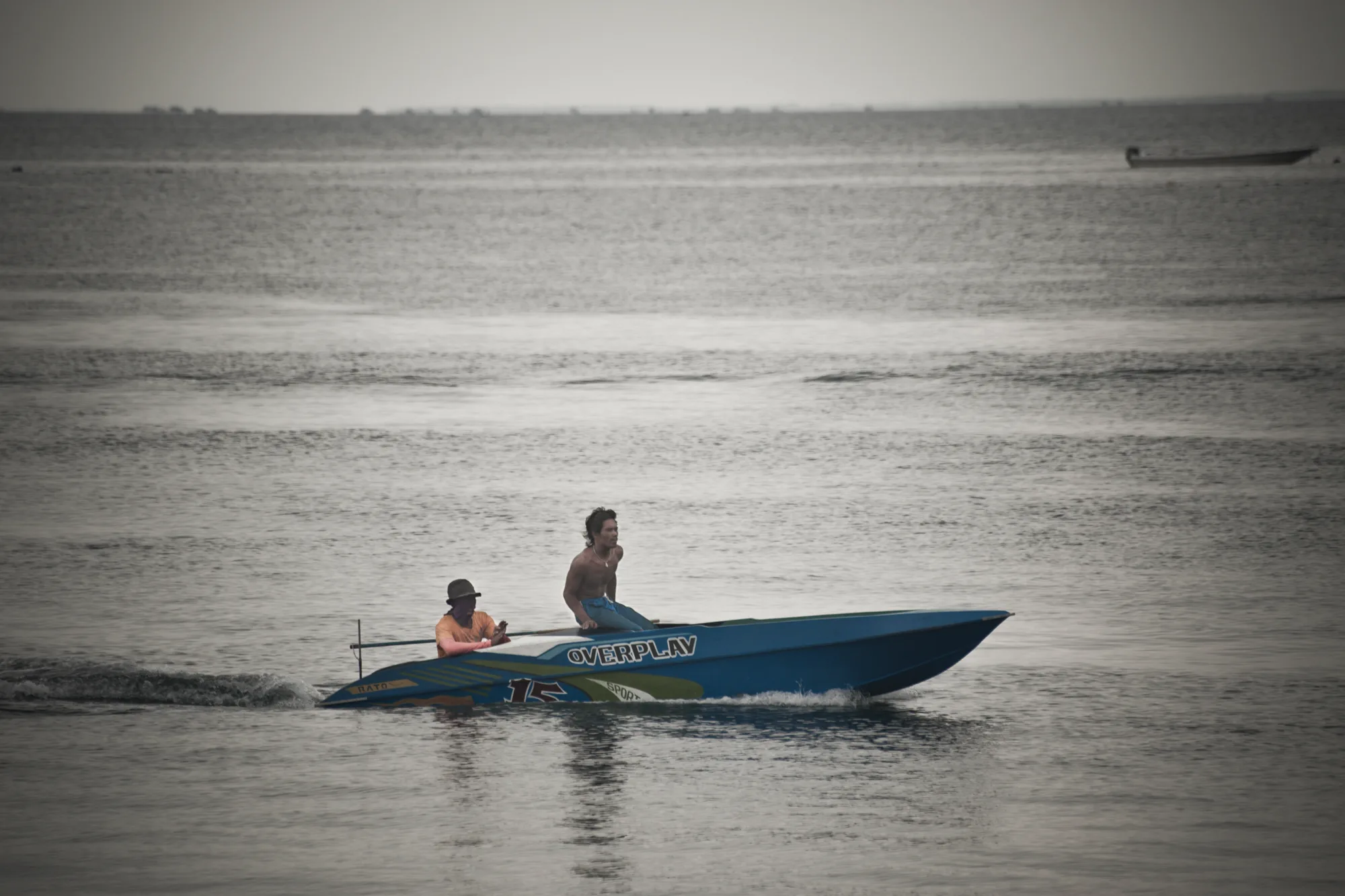 Two young men in a blue speedboat — Borneo & Pulau Mabul, documentary and travel photography by Janina Laszlo