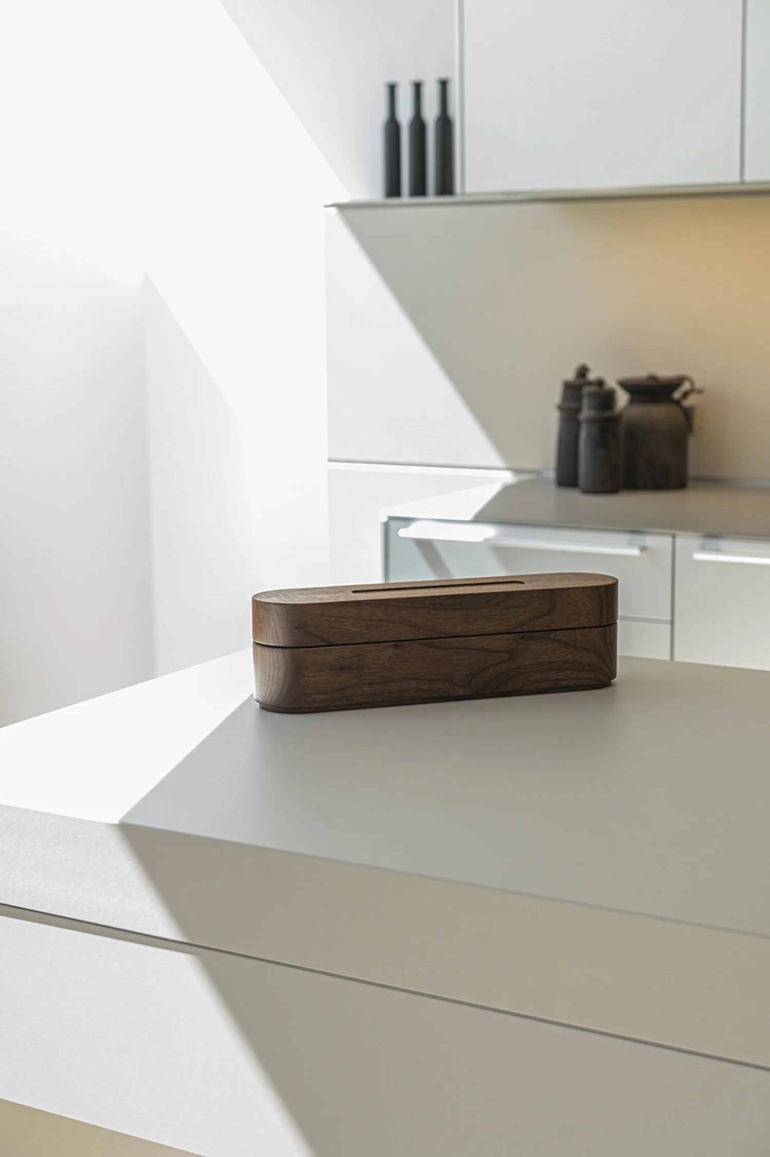 Wooden bulthaup container on a white kitchen island, minimalist kitchen architecture — campaign photography by Janina Laszlo, Munich