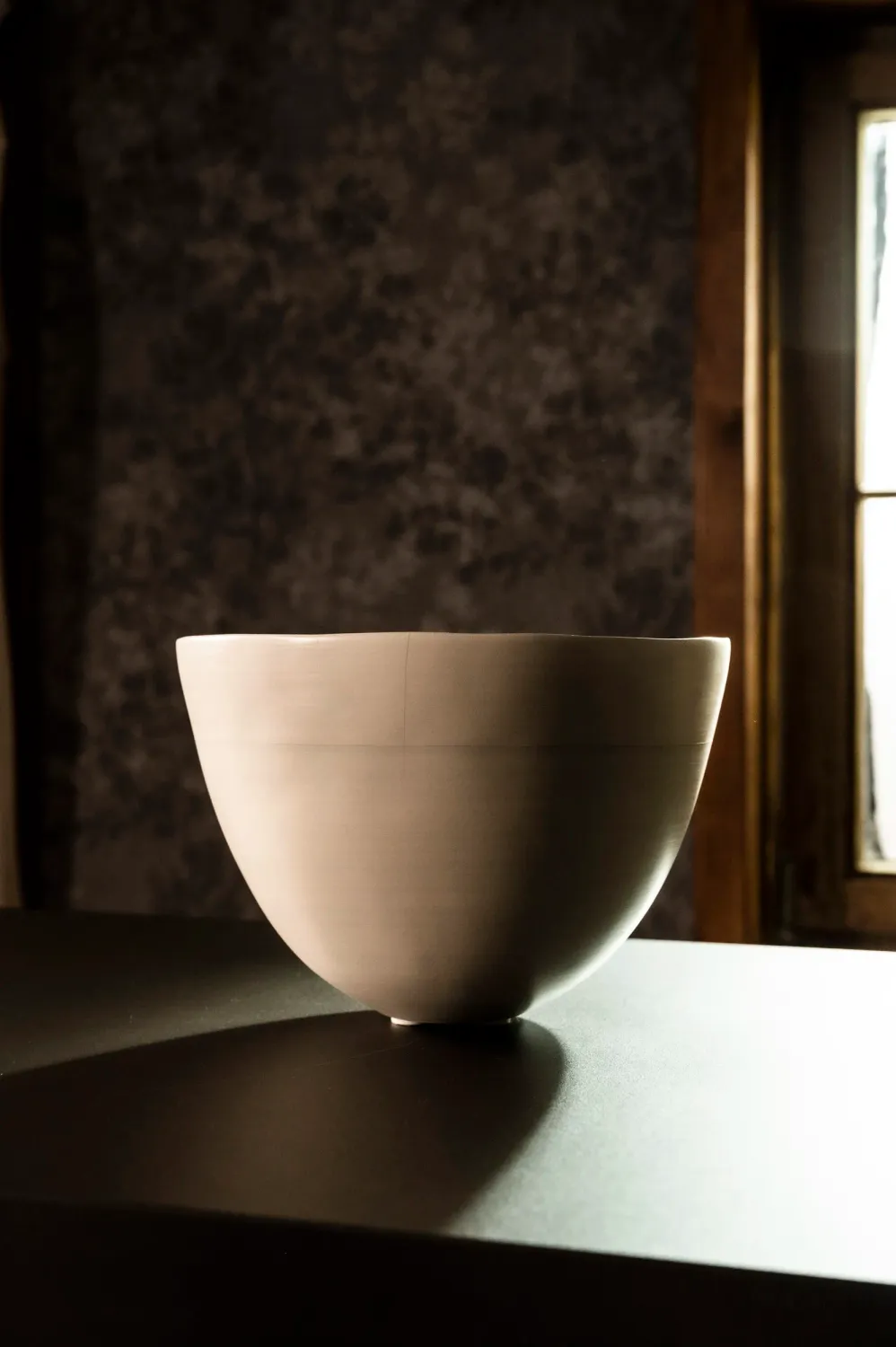 Cream ceramic bowl on a black bulthaup worktop — campaign photography by Janina Laszlo, Munich