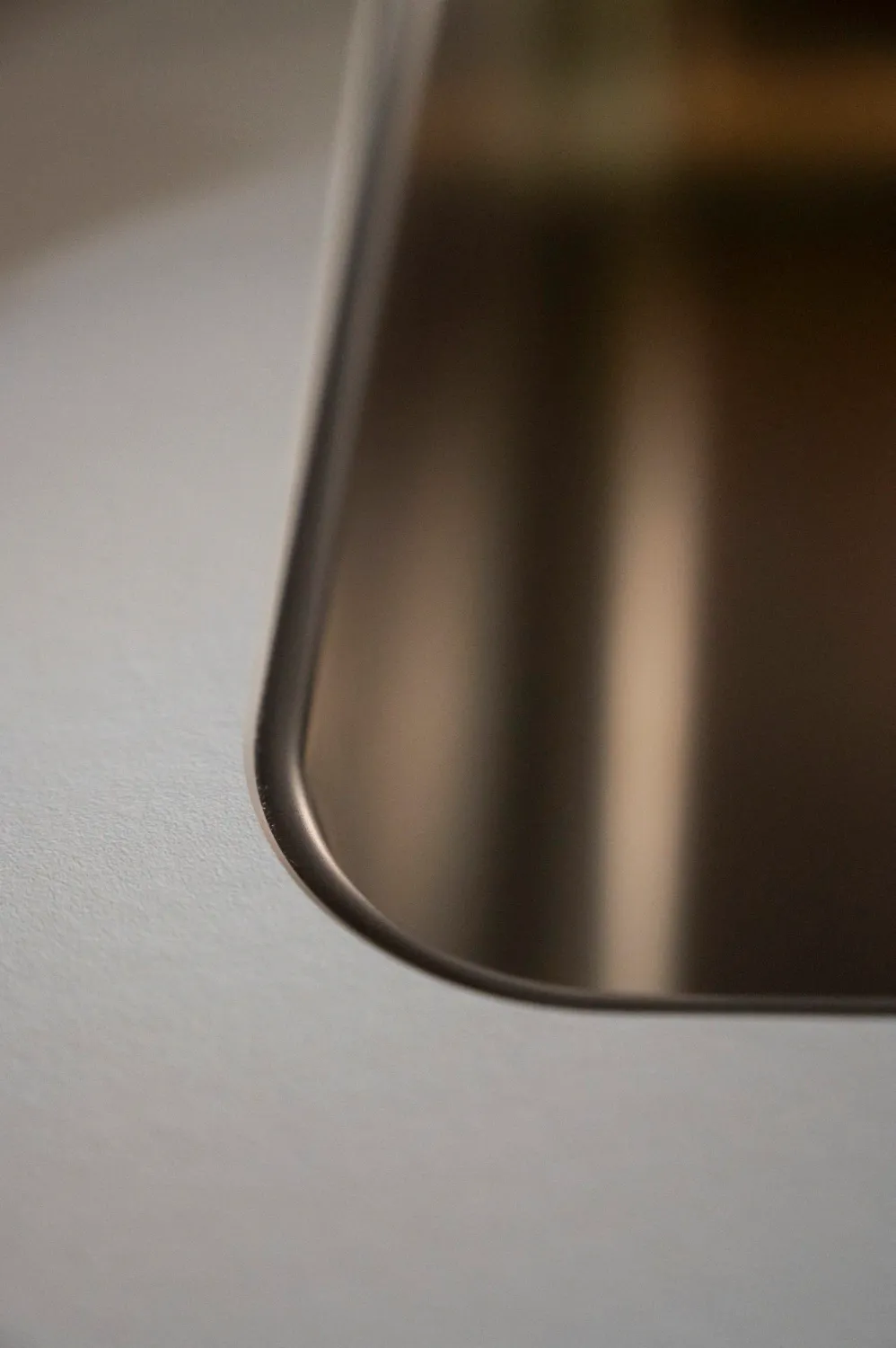 Seamless stainless steel sink edge in a bulthaup worktop — campaign photography by Janina Laszlo, Munich