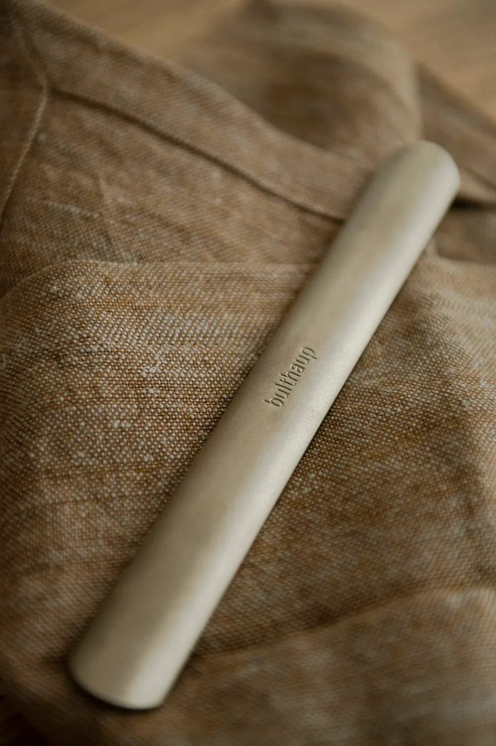 Ceramic rolling pin on natural linen — campaign photography by Janina Laszlo, Munich