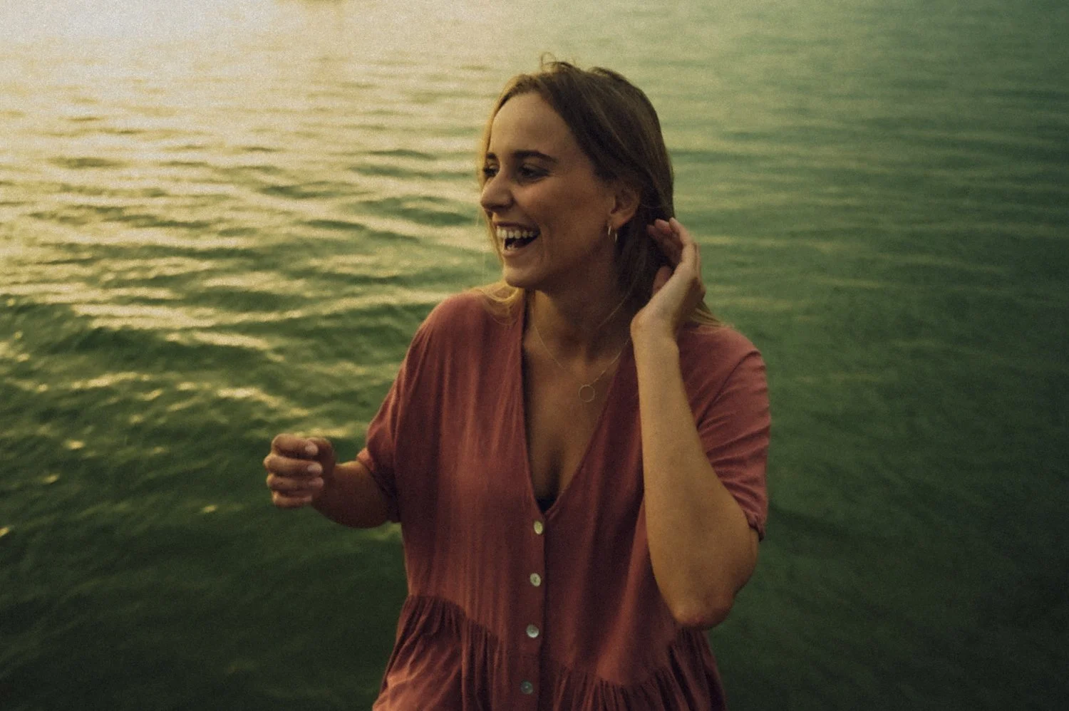 Laughing woman with windblown hair by the water at sunset, Germany — Deutsche Telekom FaceTime Session, commercial and lifestyle photography by Janina Laszlo