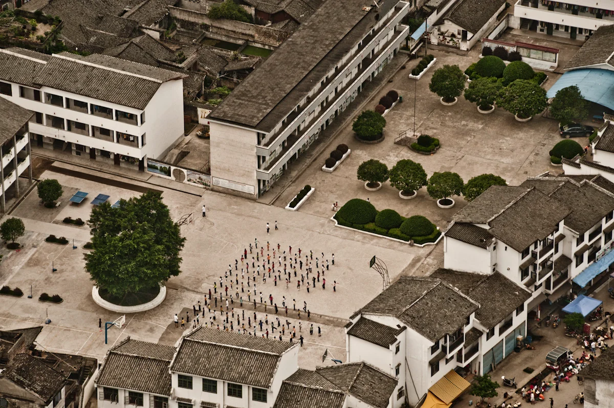 Pupils doing morning exercises in a school courtyard seen from above, Xingping — China, documentary and travel photography by Janina Laszlo