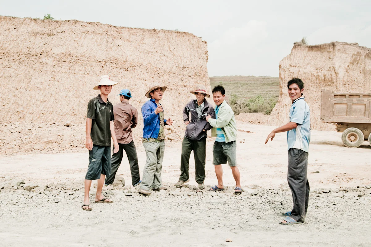 Laughing workers in a sand quarry beside a lorry, Hainan — China, documentary and travel photography by Janina Laszlo