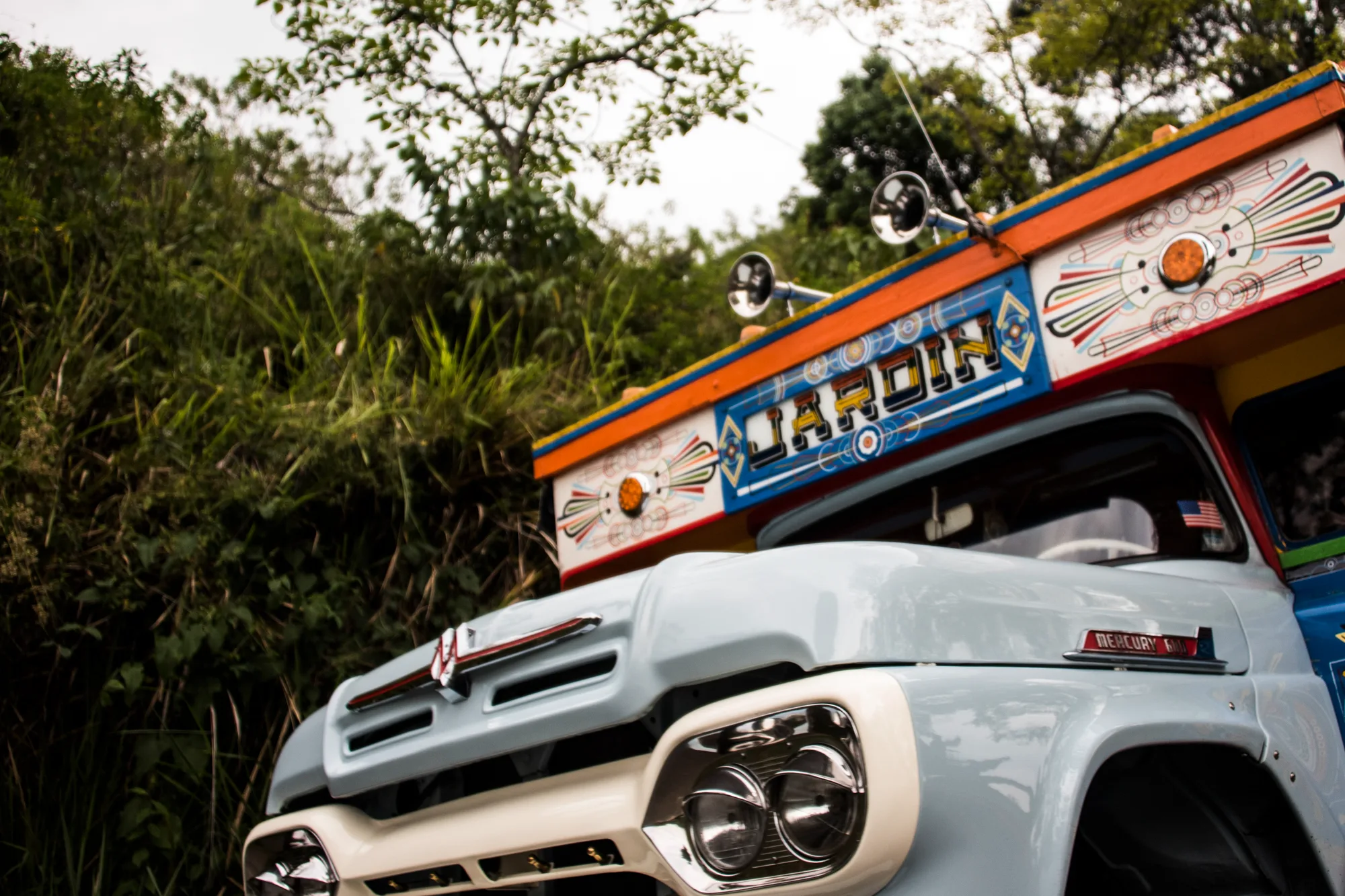 Front of a pale blue vintage Mercury chiva truck painted with the name Jardín, Antioquia — Colombia, travel and documentary photography by Janina Laszlo