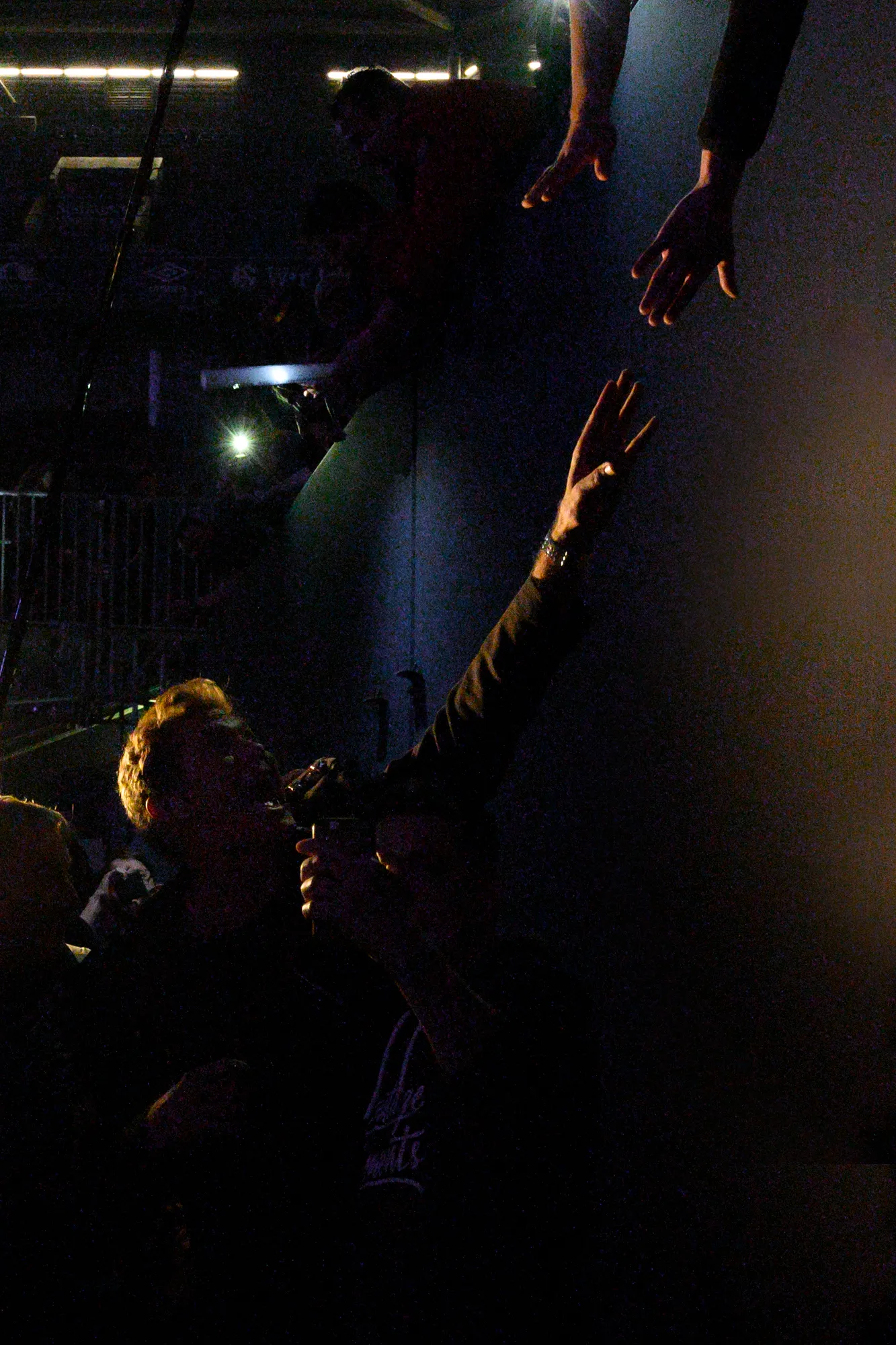David Hasselhoff reaching up towards fans' hands in the dark during a concert appearance — behind-the-scenes photography by German photographer Janina Laszlo