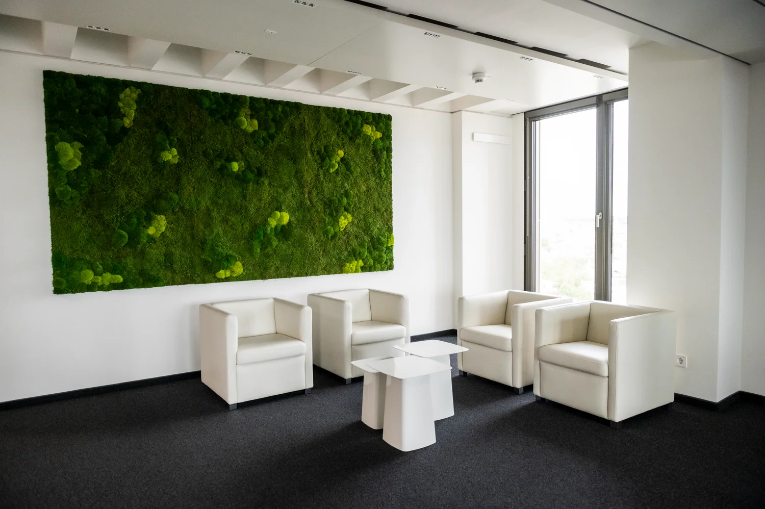 Lounge with white leather armchairs and a large moss wall at the Digital+ office tower, Frankfurt am Main — Digital+, corporate photography by Janina Laszlo