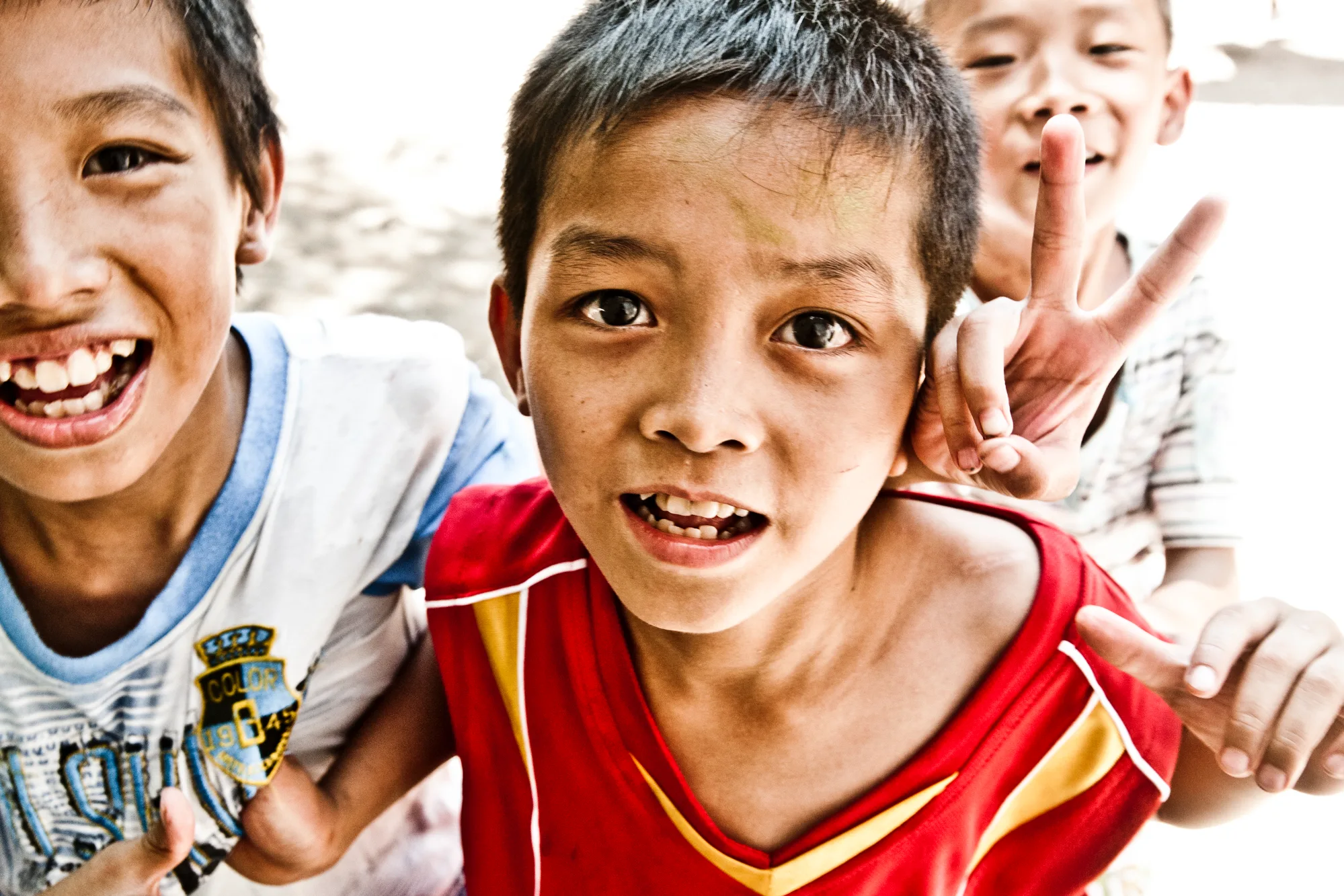 Laughing boys crowding close to the camera — Dragon Boat Festival Hainan, documentary photography by Janina Laszlo