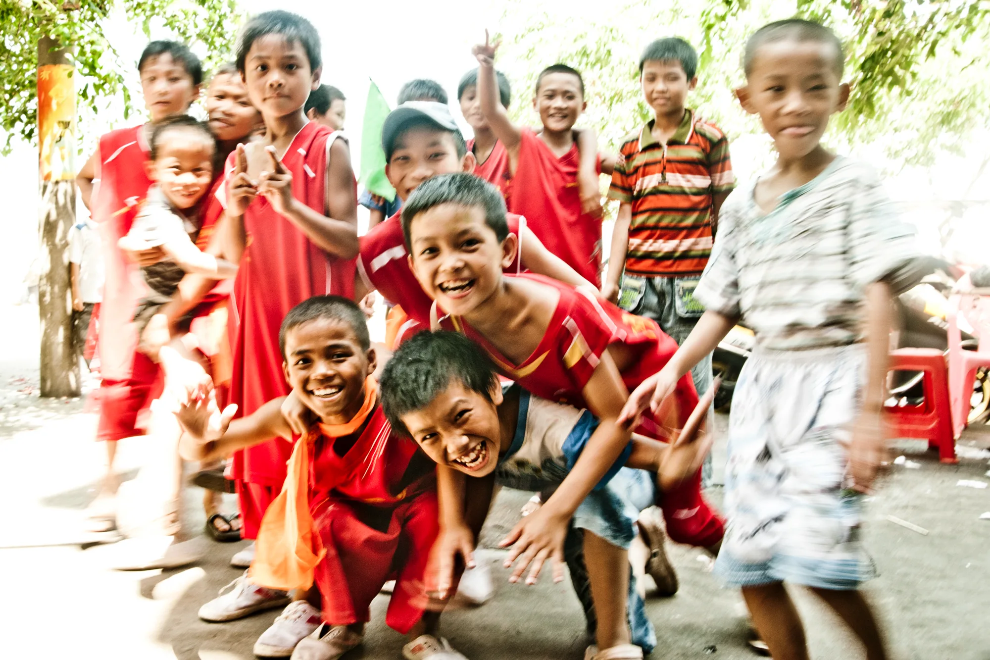 Crowd of grinning boys in red festival clothes — Dragon Boat Festival Hainan, documentary photography by Janina Laszlo