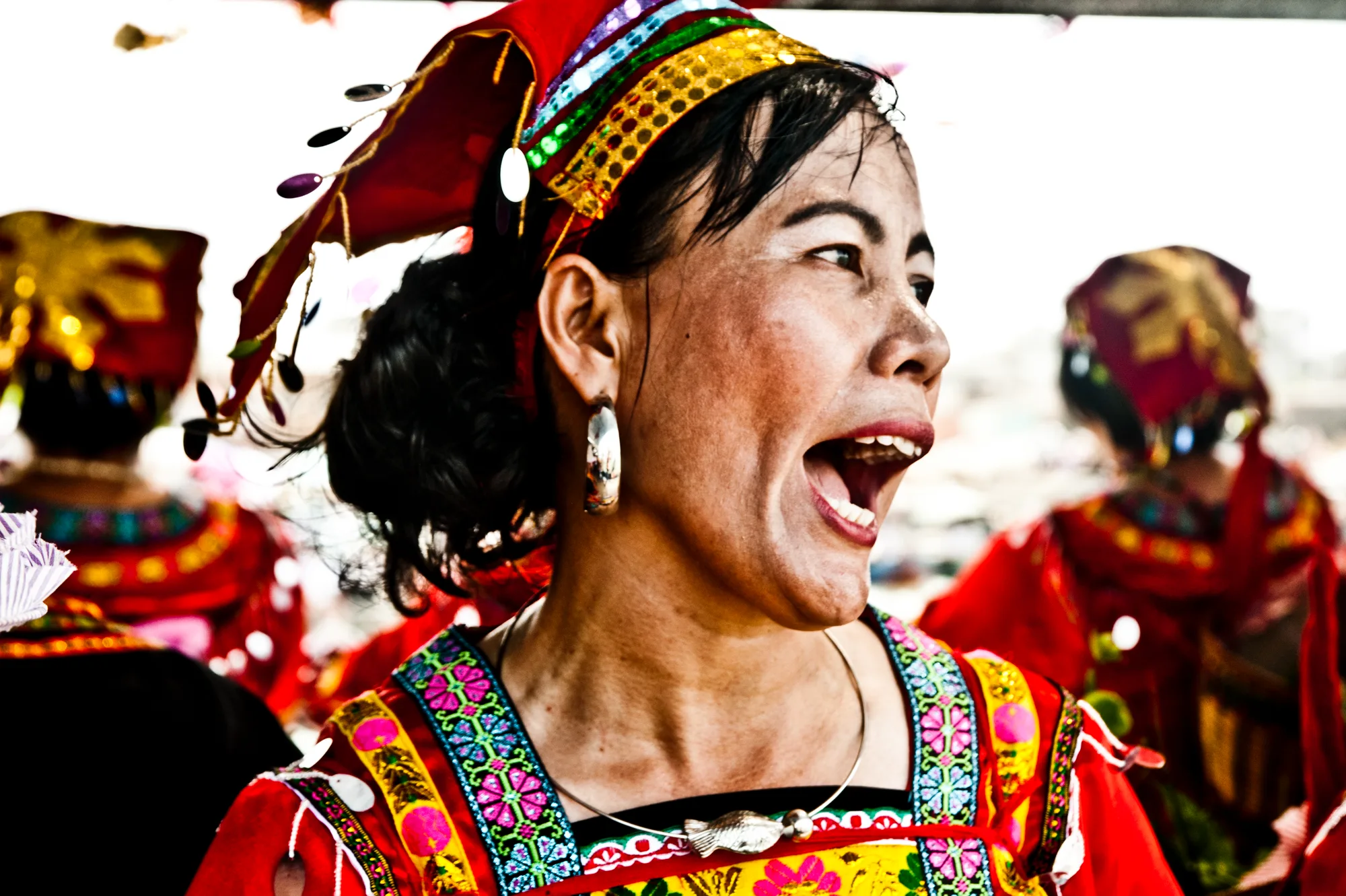 Woman in a traditional headdress shouting with joy — Dragon Boat Festival Hainan, documentary photography by Janina Laszlo