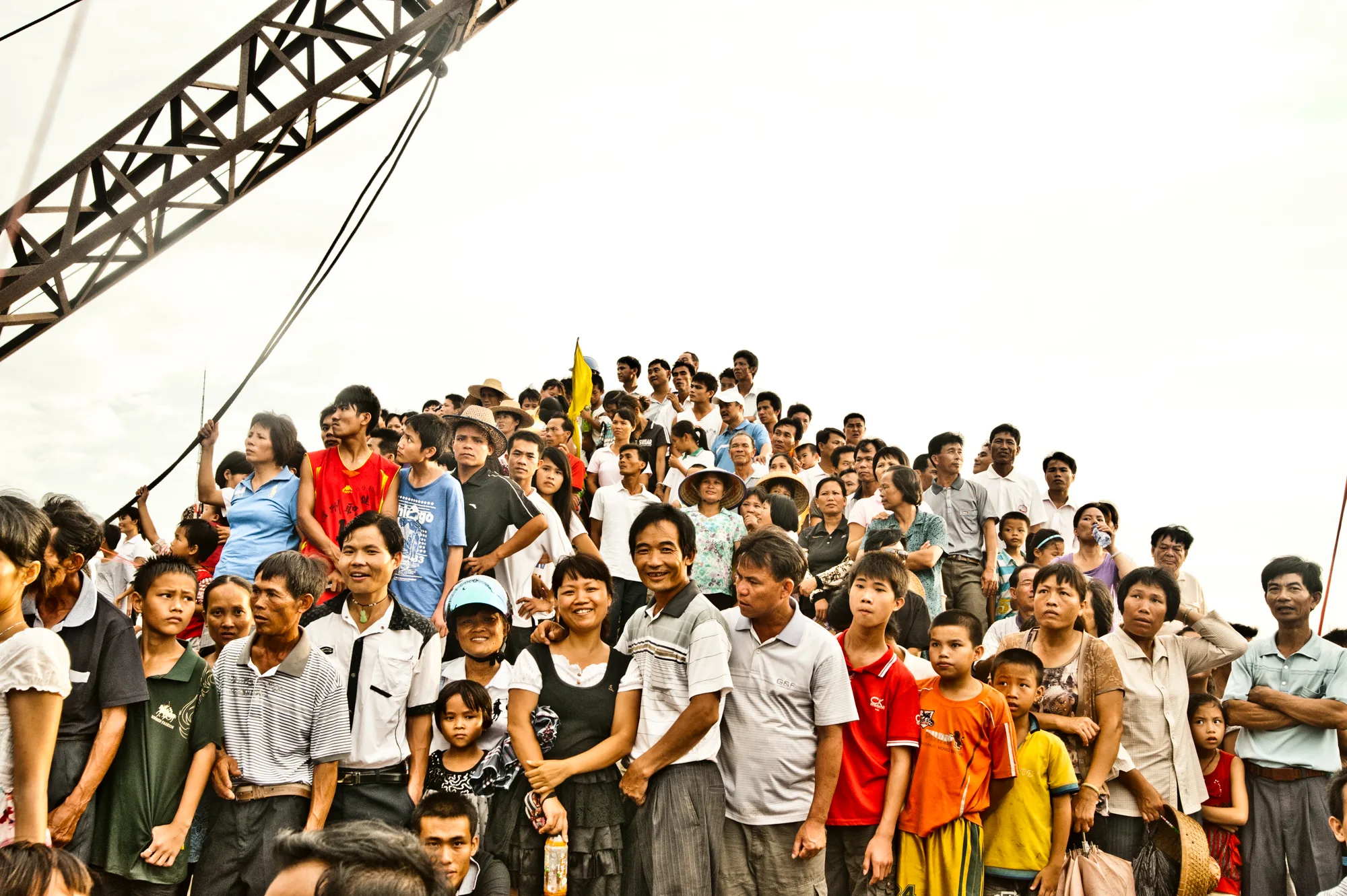 Crowd packed on the quay beneath a harbour crane — Dragon Boat Festival Hainan, documentary photography by Janina Laszlo