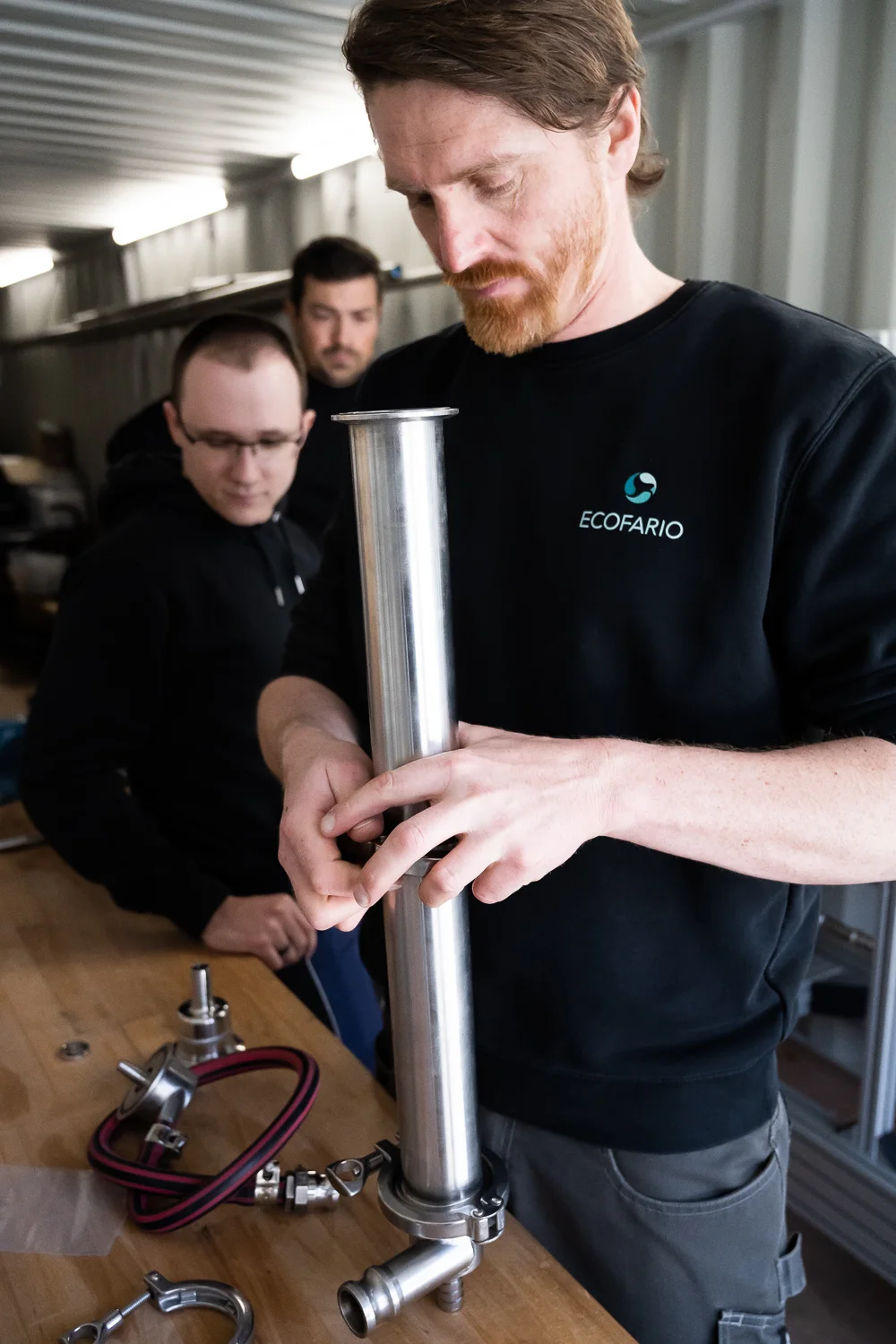 Engineer assembling a stainless steel filter tube — ECOFARIO, corporate portrait and industrial reportage photography by Janina Laszlo