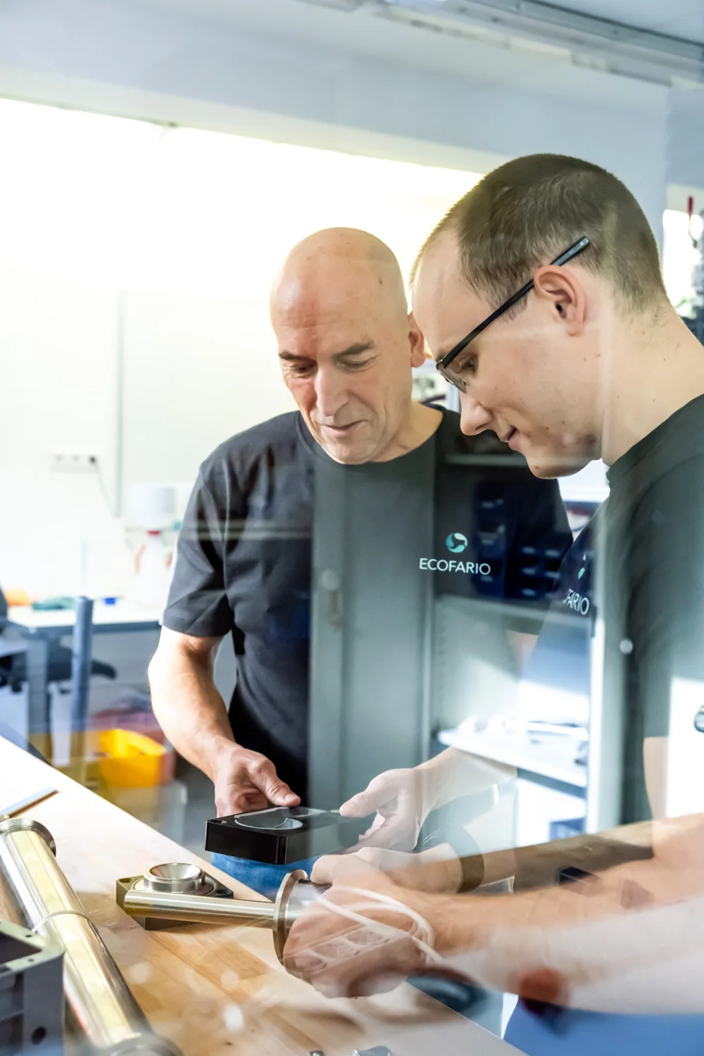 Two engineers working together at the bench — ECOFARIO, corporate portrait and industrial reportage photography by Janina Laszlo