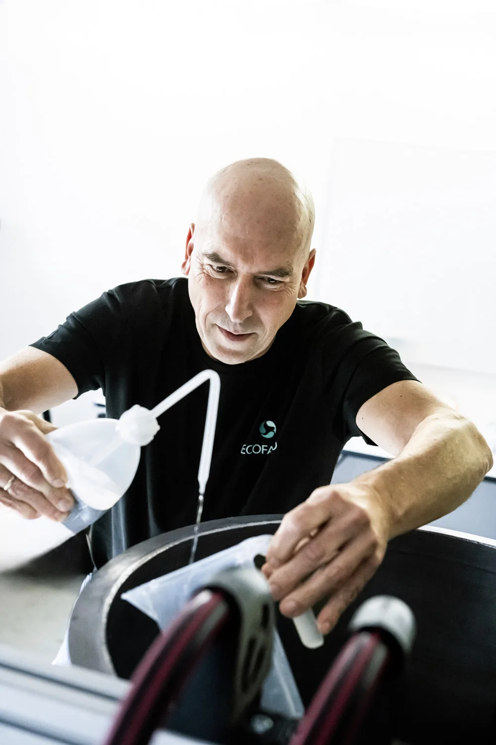 Engineer with a shaved head fitting tubing — ECOFARIO, corporate portrait and industrial reportage photography by Janina Laszlo