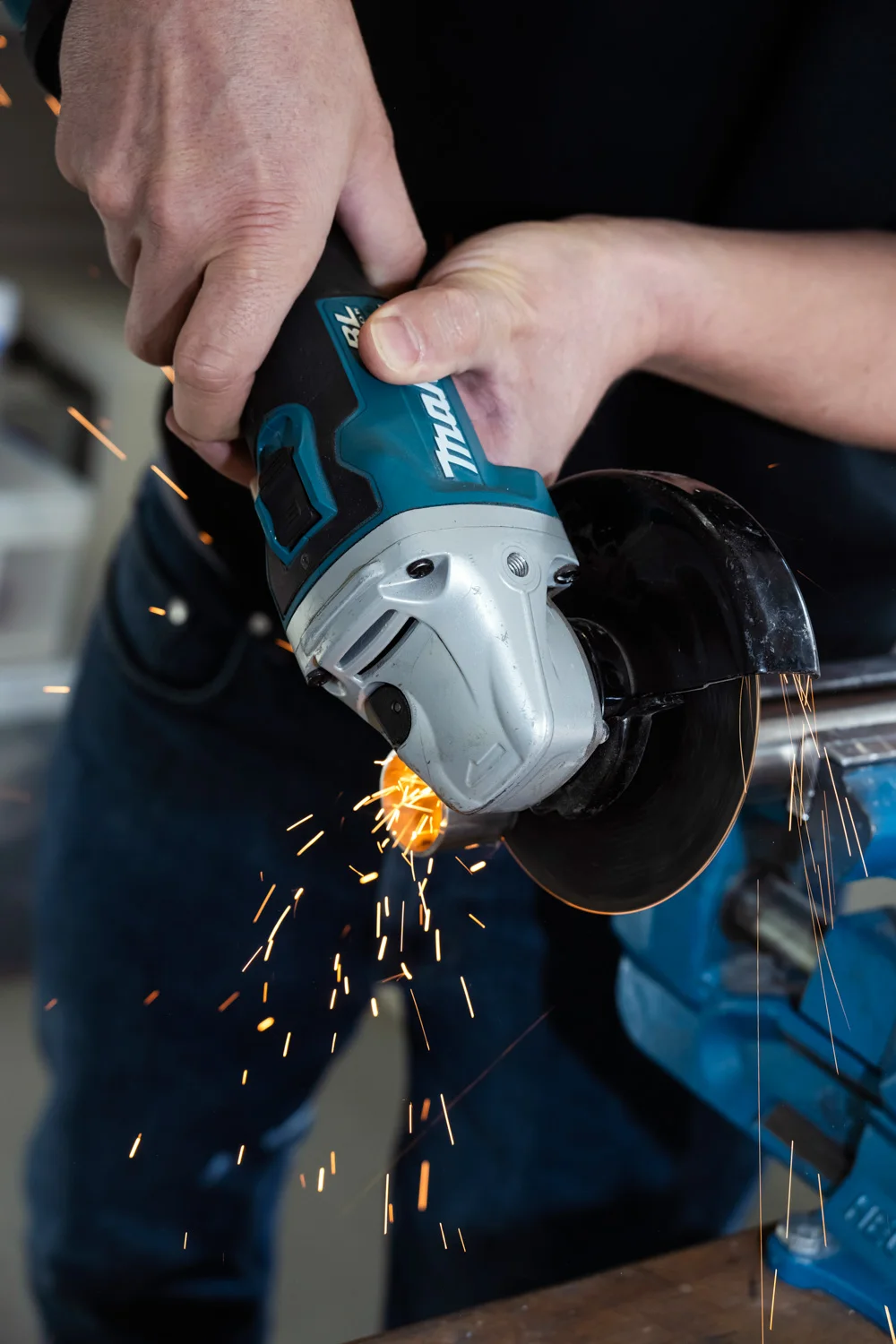 Hands operating an angle grinder, sparks flying — ECOFARIO, corporate portrait and industrial reportage photography by Janina Laszlo