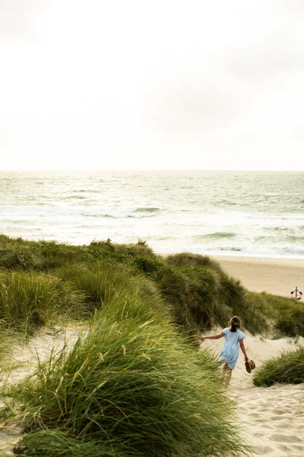 Small child walking down a dune path towards the sea — Ernsting's family kidswear, Klitmøller, Denmark — campaign photography by Janina Laszlo, Munich