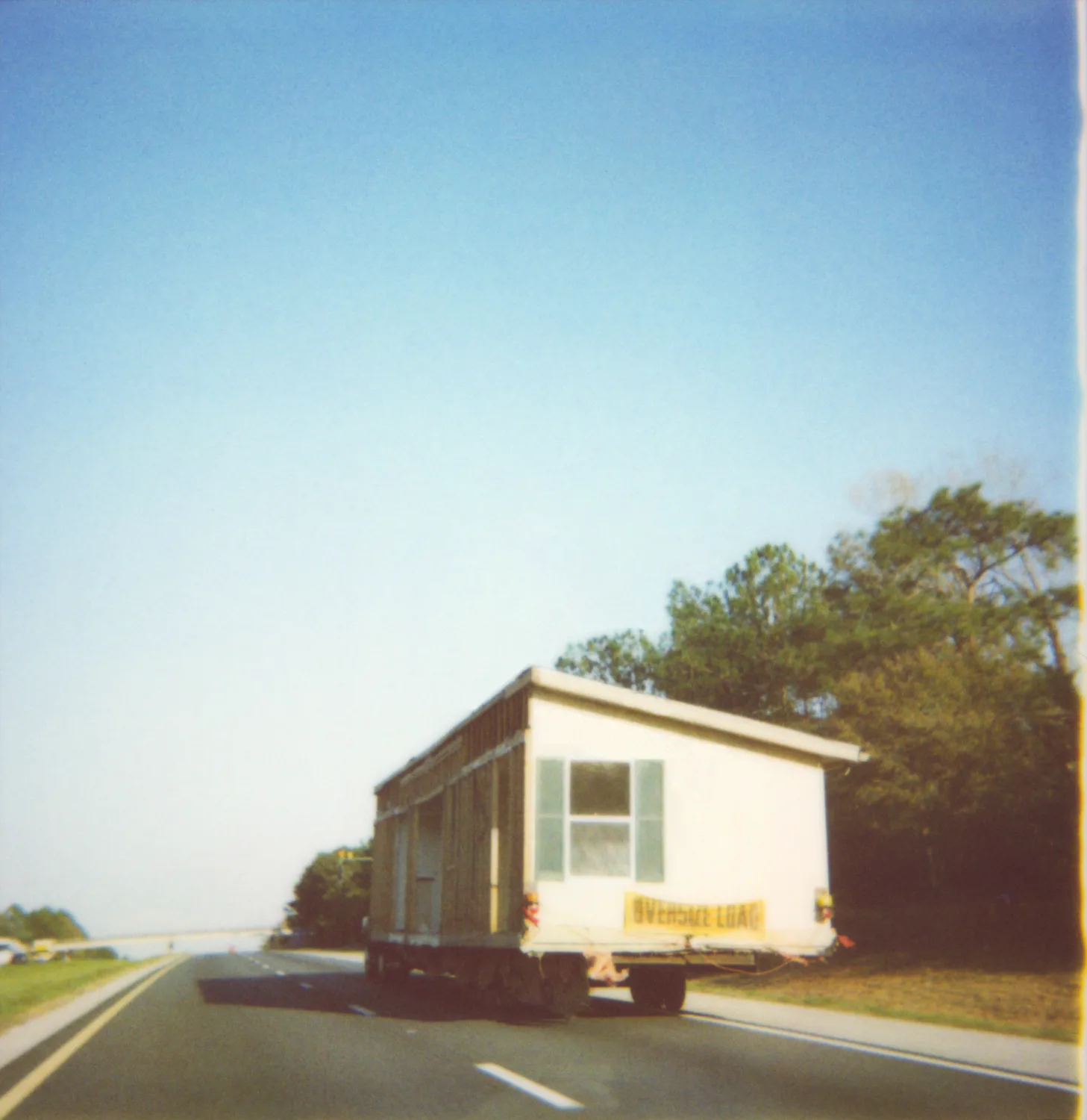 Mobile home on a truck, oversize load on the highway — Expired Polaroids in Florida, fine art and analog photography by Janina Laszlo