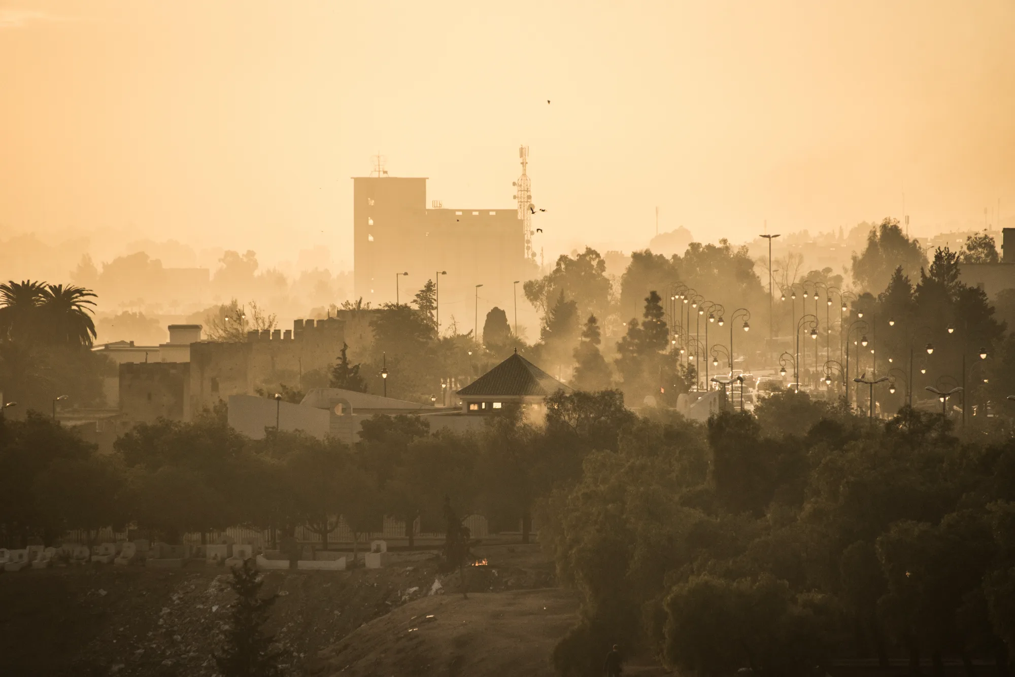 Hazy golden sunset over the city walls and street lights, Fez — Fez, street and travel photography by Janina Laszlo