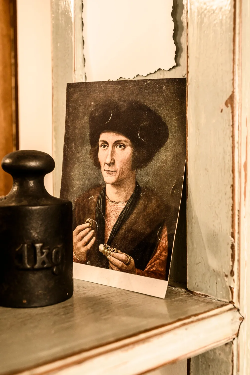 Old painted portrait and a brass weight on a workshop shelf — goldsmith Gerd Weickmann — reportage by Janina Laszlo, photographer in Munich