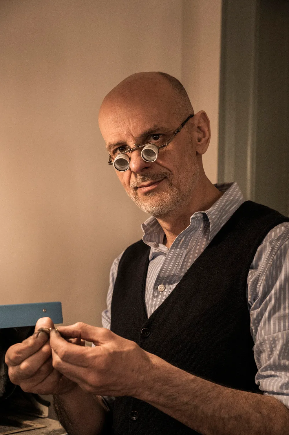 Gerd Weickmann with round glasses examining a ring at his bench — goldsmith Gerd Weickmann — reportage by Janina Laszlo, photographer in Munich