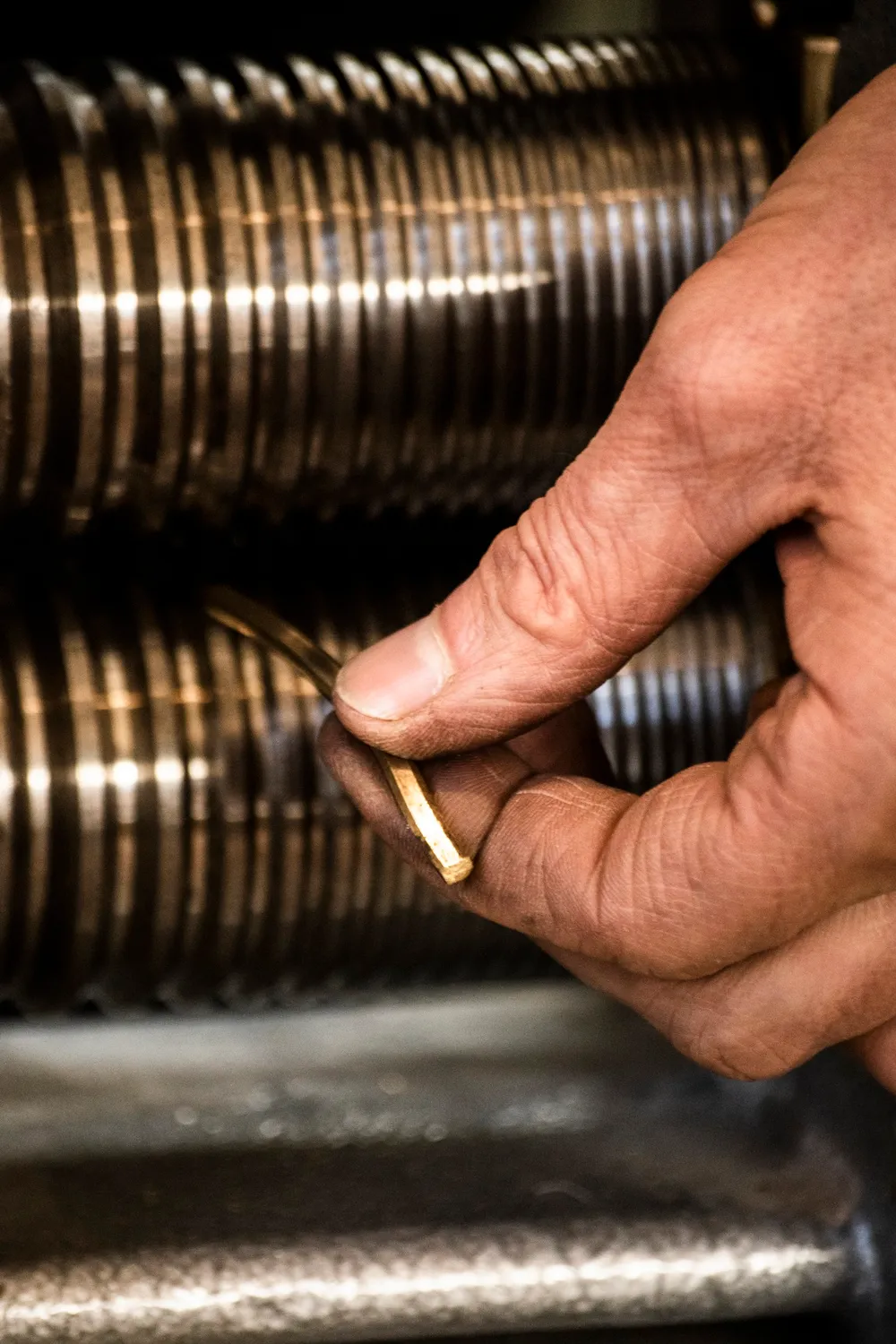 Hand guiding gold wire through a rolling mill — goldsmith Gerd Weickmann — reportage by Janina Laszlo, photographer in Munich