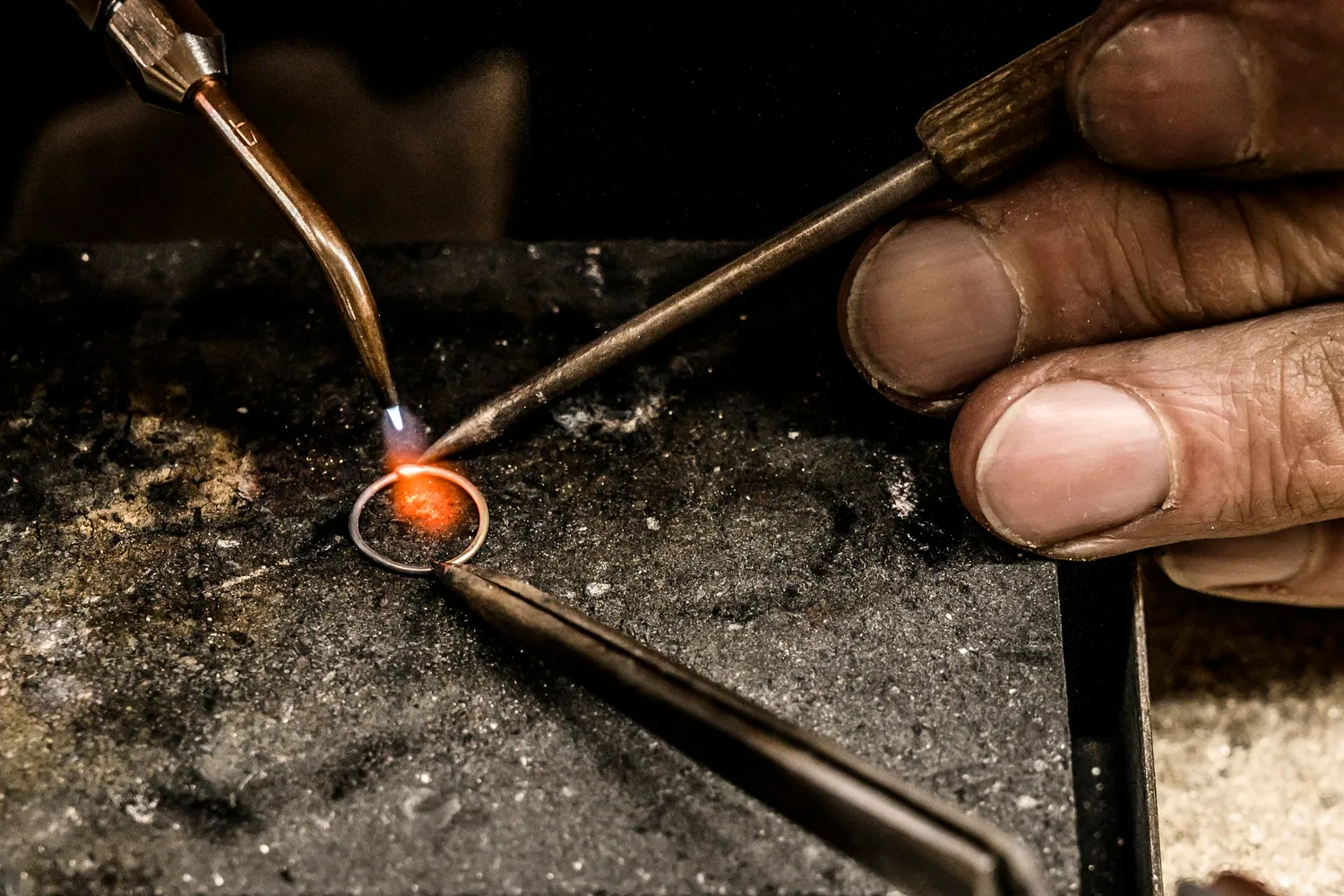 Soldering flame heating a ring on a charcoal block, close-up — goldsmith Gerd Weickmann — reportage by Janina Laszlo, photographer in Munich