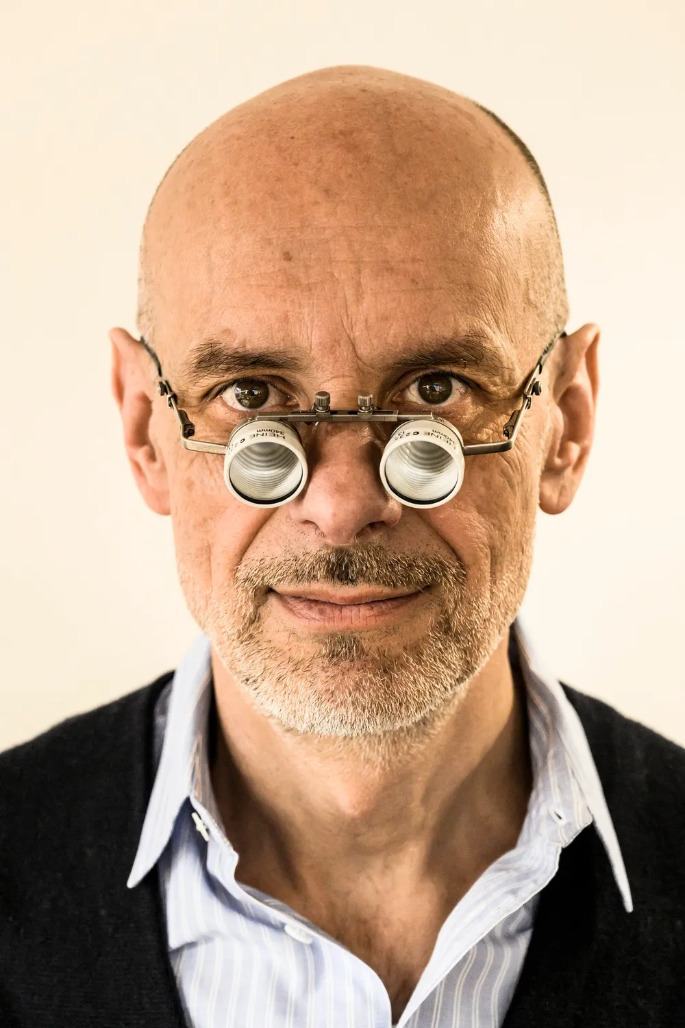 Gerd Weickmann wearing loupe glasses, looking straight into the camera — goldsmith Gerd Weickmann — reportage by Janina Laszlo, photographer in Munich