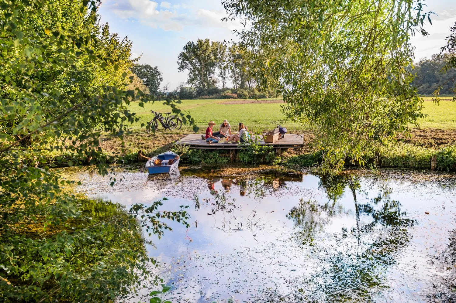 Cyclists picnicking on a wooden jetty by a pond along the Hop Route, Bavaria — cycling tourism campaign for the Bavarian Tourism Association, photographed by German commercial photographer Janina Laszlo