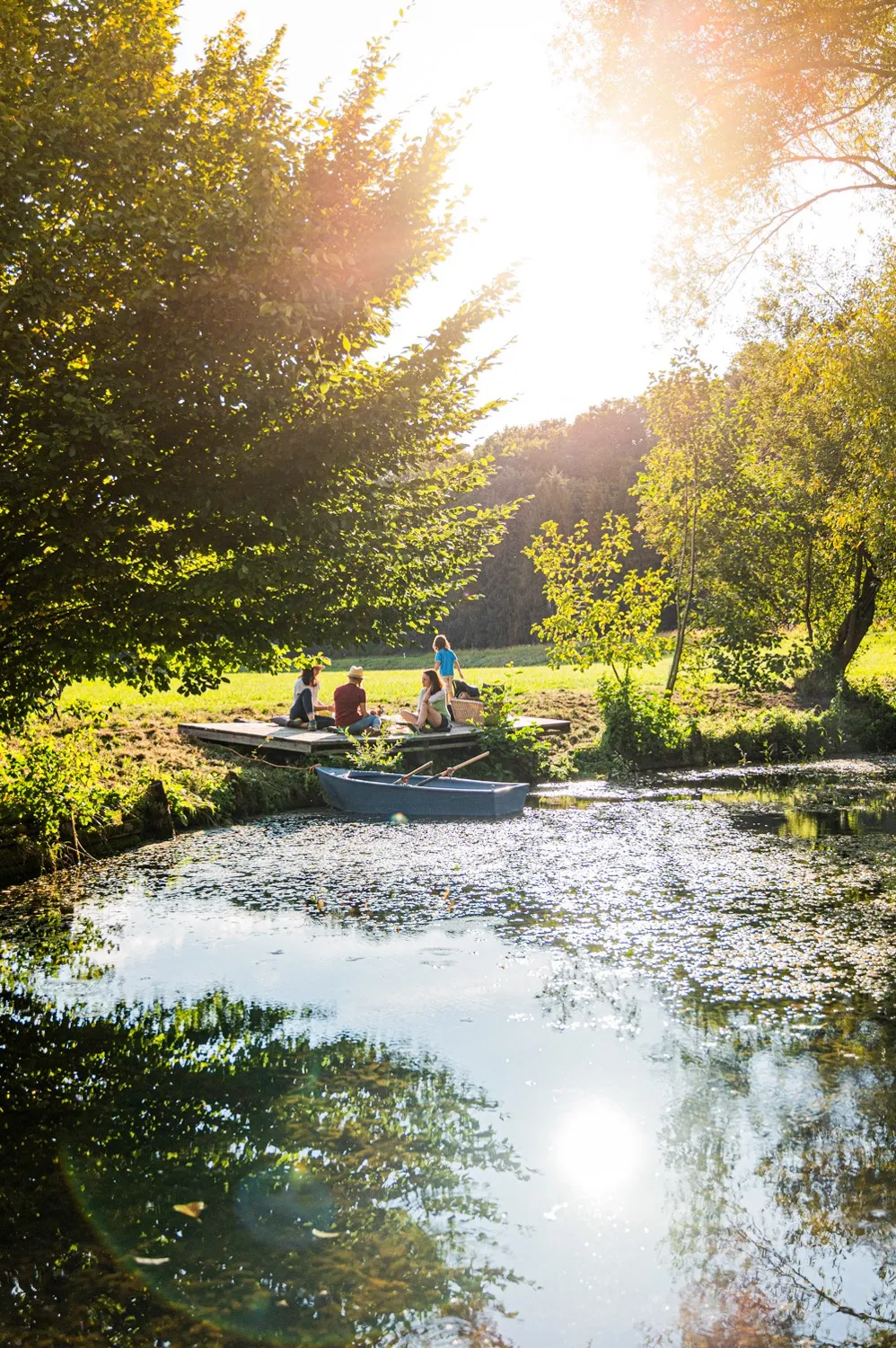 Picnic on a jetty by a sunlit pond during a cycling tour of the Hop Route — outdoor lifestyle photography for a Bavarian tourism campaign by Janina Laszlo