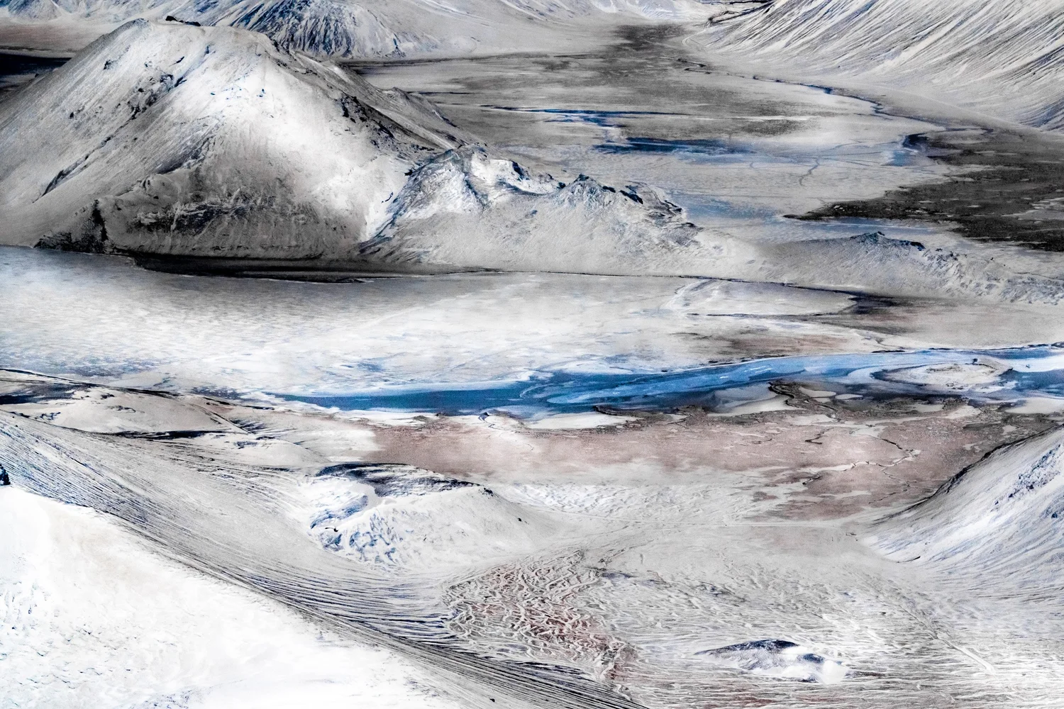 Aerial abstract of glacial river channels cutting through grey-blue sediment, Iceland — travel photography by Janina Laszlo
