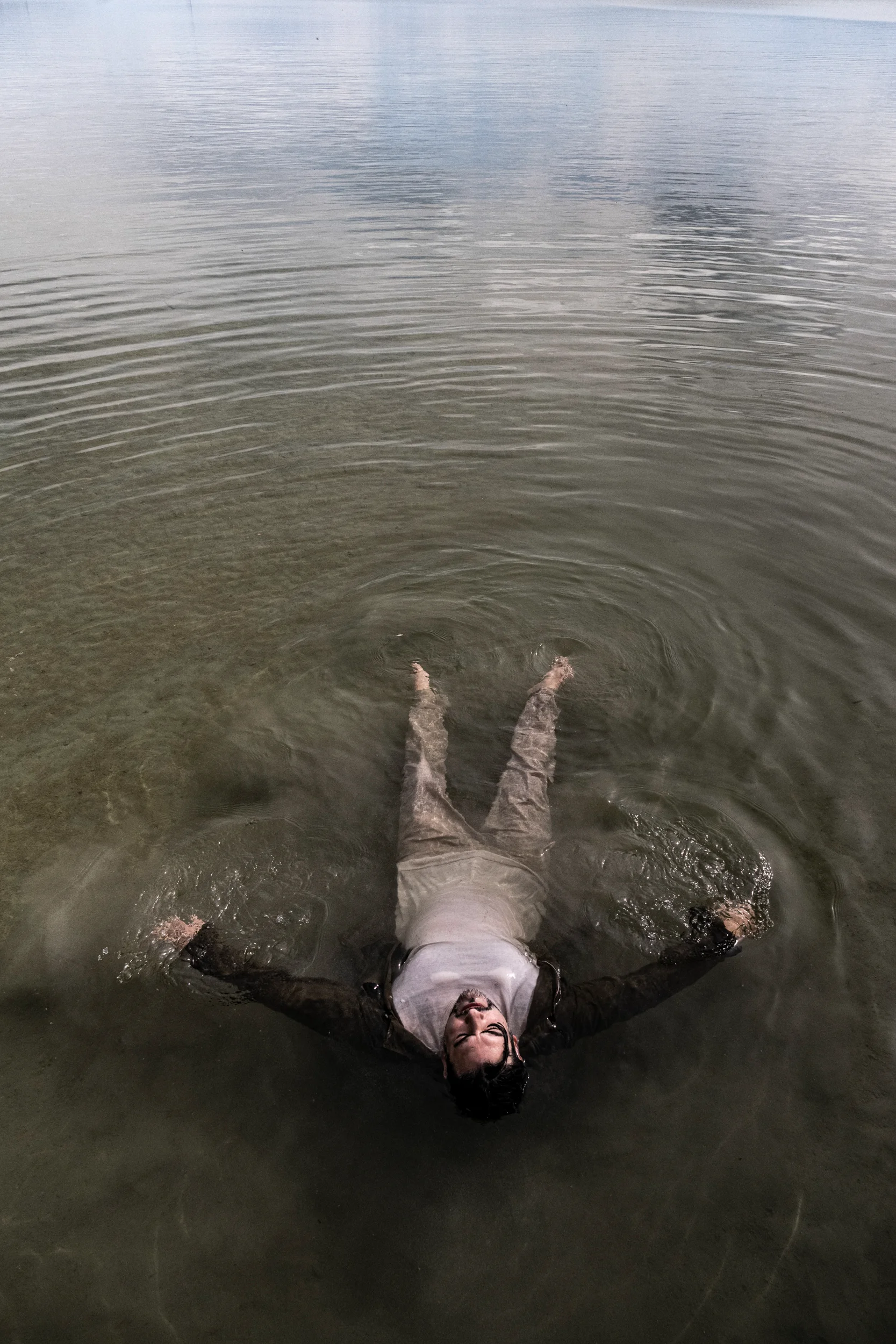 Ilker Arcayürek floating on his back in the lake, seen from above — Ilker Arcayürek, artist portrait photography by Janina Laszlo