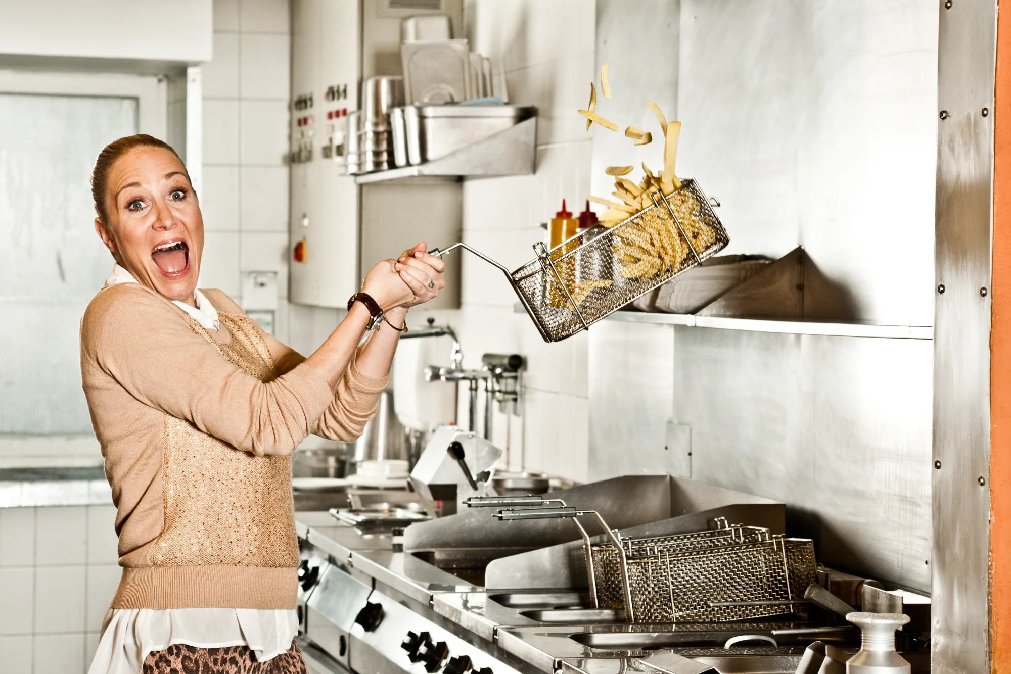 Janine Kunze laughing in a restaurant kitchen — IN Magazin, celebrity editorial photography by Janina Laszlo