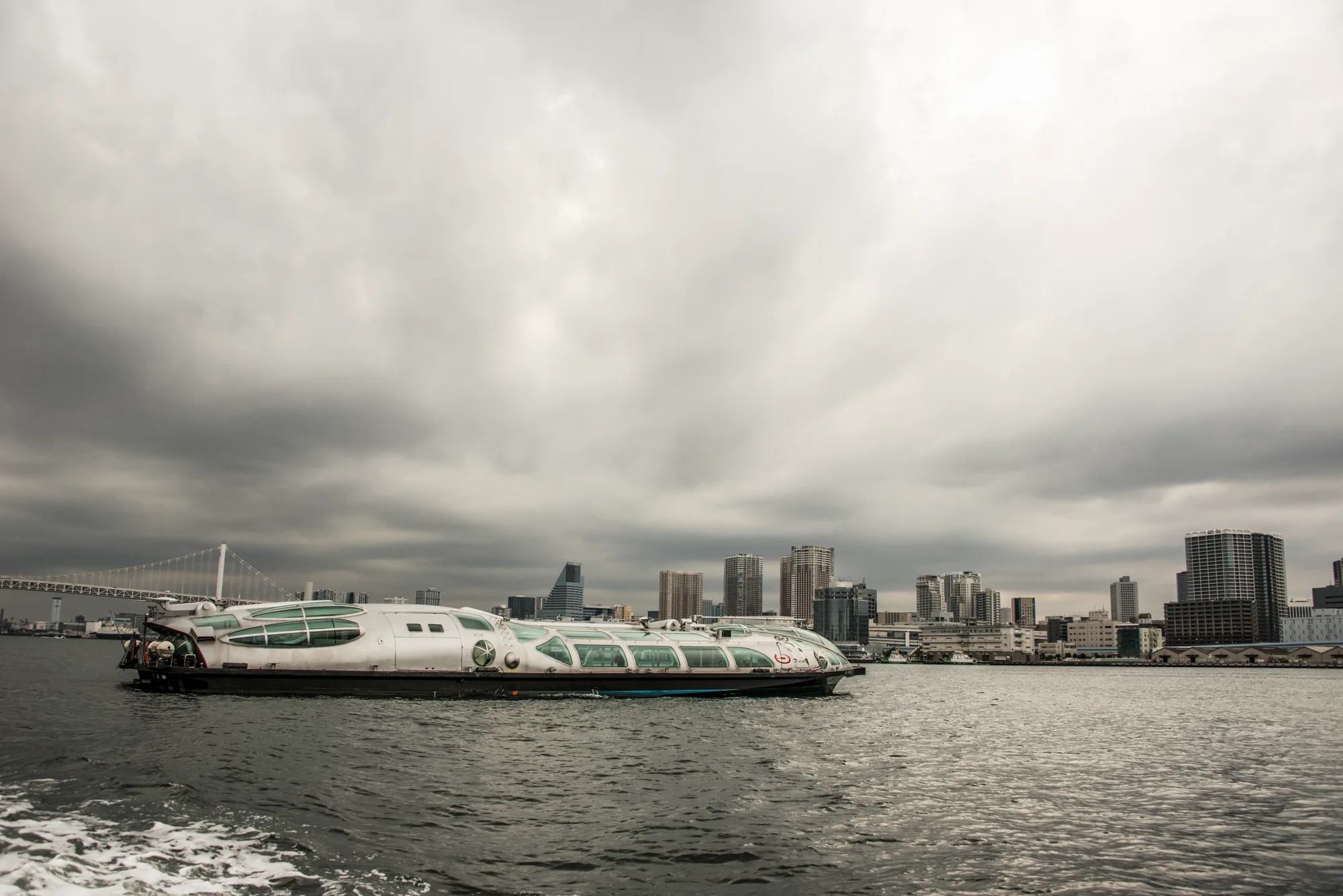 Futuristic Himiko water bus on Tokyo Bay under storm clouds — Japan, travel and street photography by Janina Laszlo