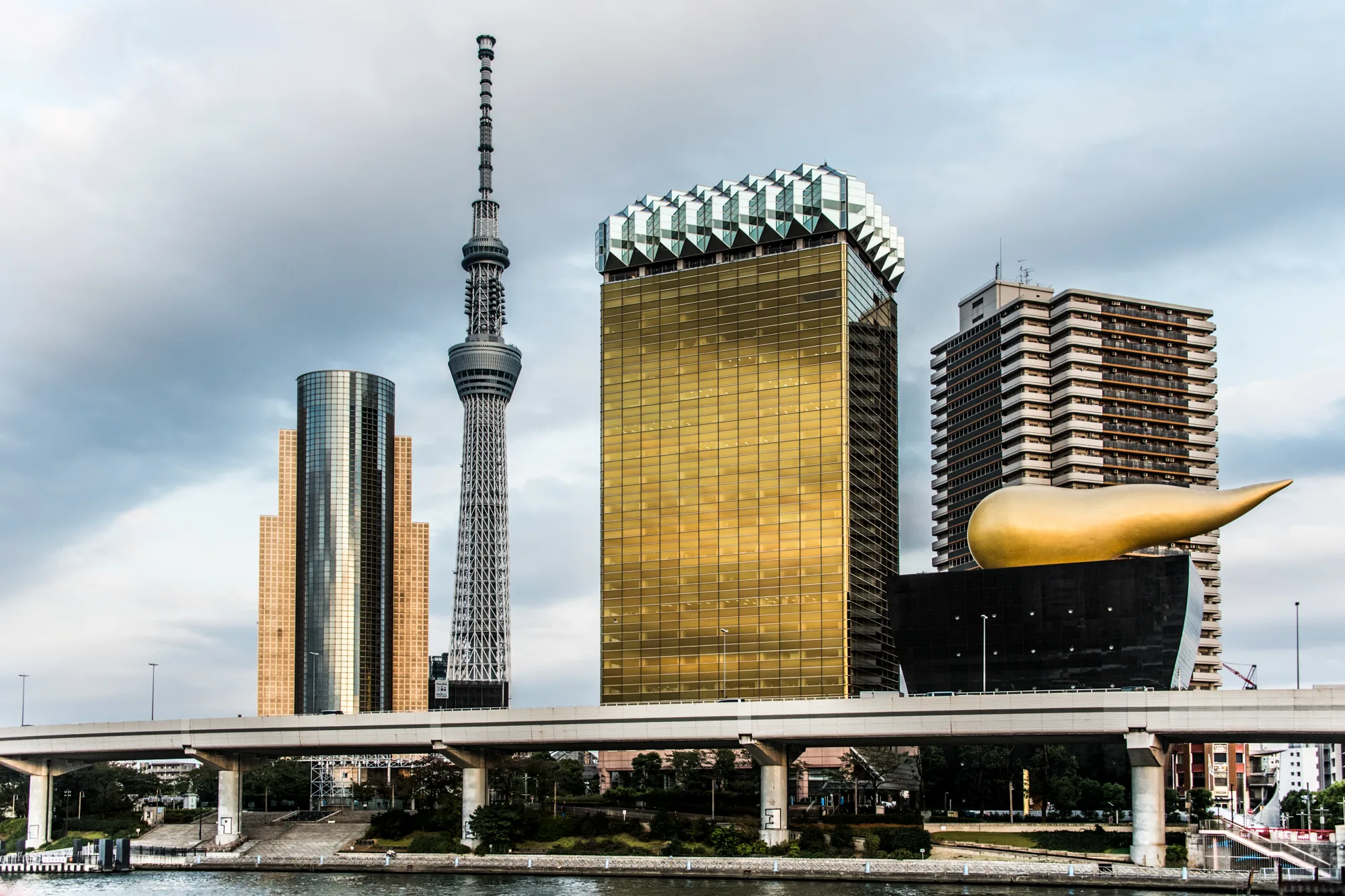Asahi Beer Hall with the golden flame and Tokyo Skytree across the Sumida River, Tokyo — Japan, travel and street photography by Janina Laszlo