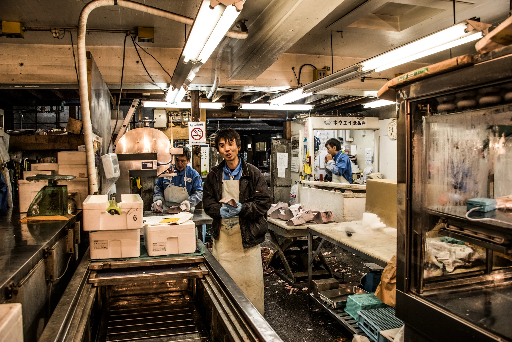 Fishmongers cutting tuna in a market stall, Tsukiji fish market, Tokyo — Japan, travel and street photography by Janina Laszlo
